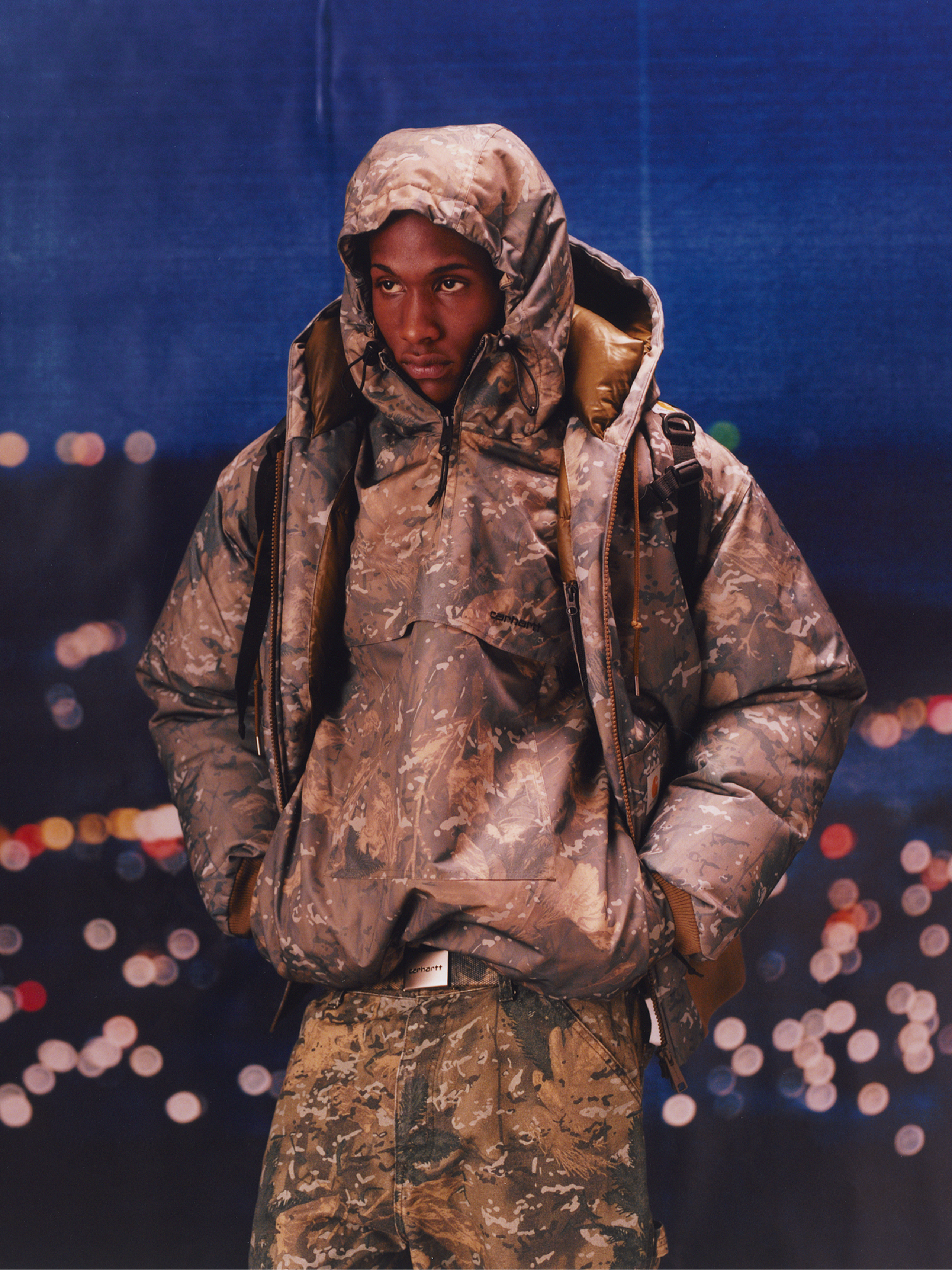Model wearing an all camo outfit in the Carhartt WIP F/W25 Men's Lookbook