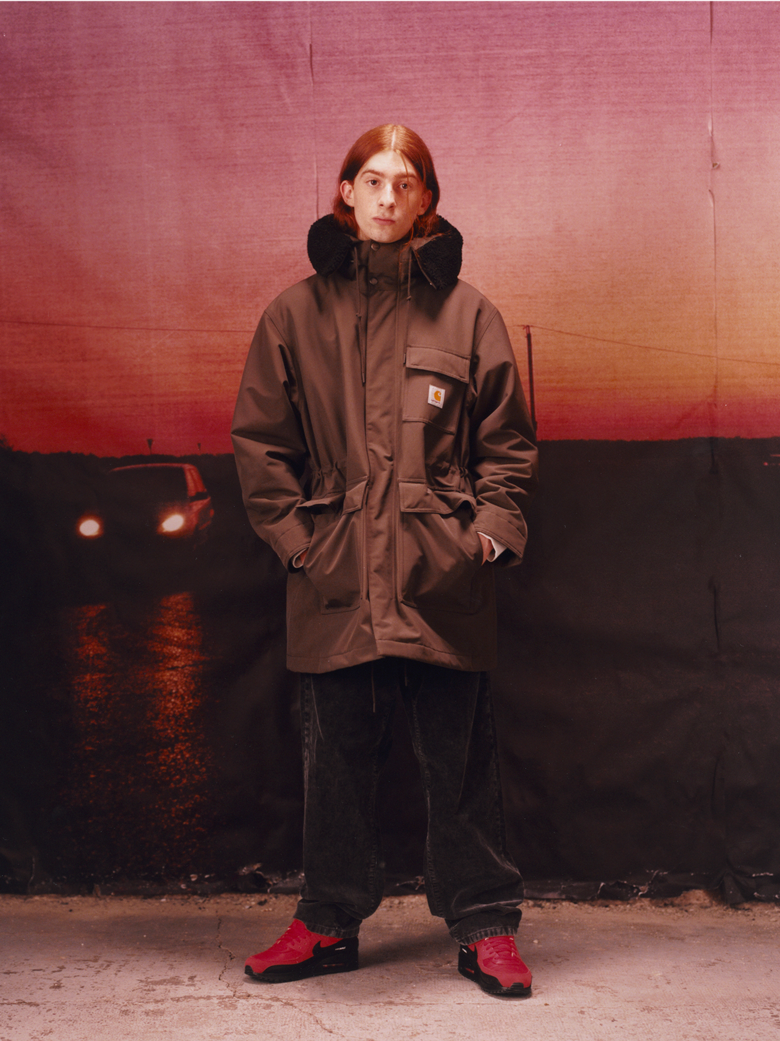 Model wearing hooded coat in the Carhartt WIP F/W25 Men's Lookbook