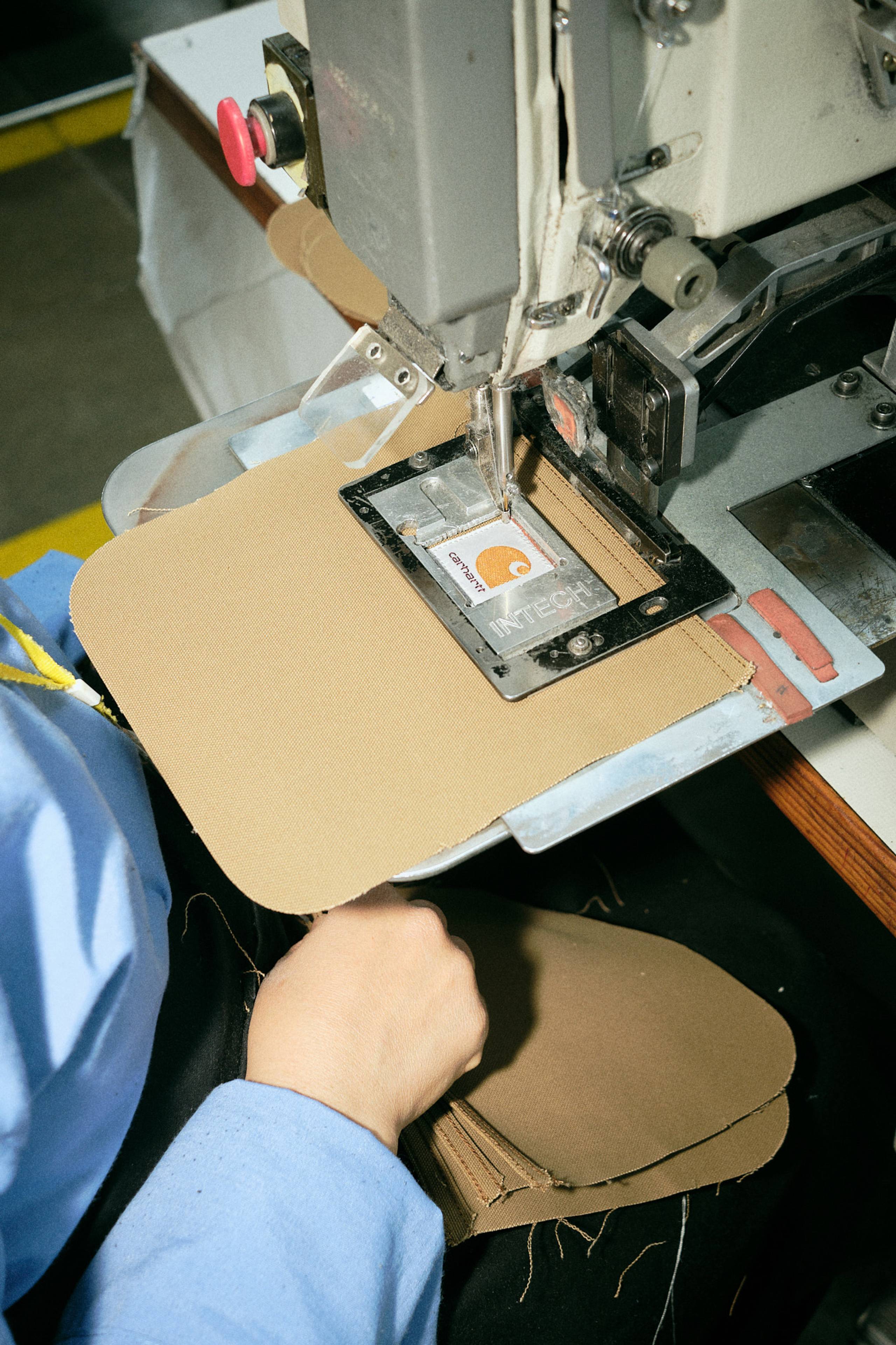 Carhartt WIP label being machine stitched onto fabric in factory