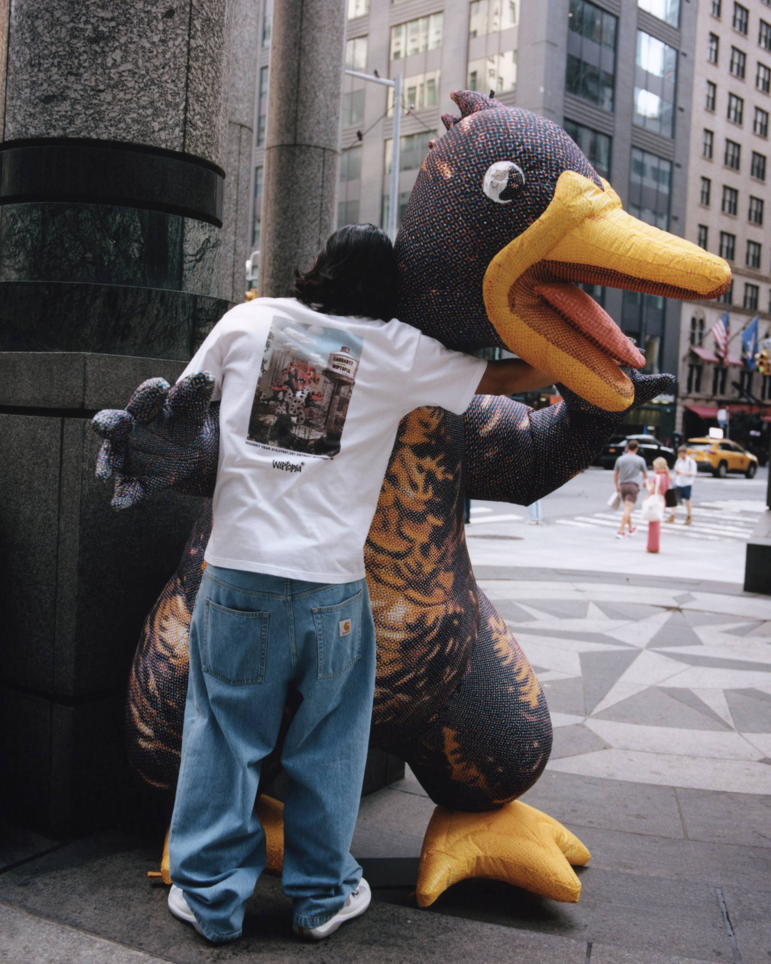Model standing with blowup Duck Monster wearing items from the Carhartt WIP Wiptopia Collection