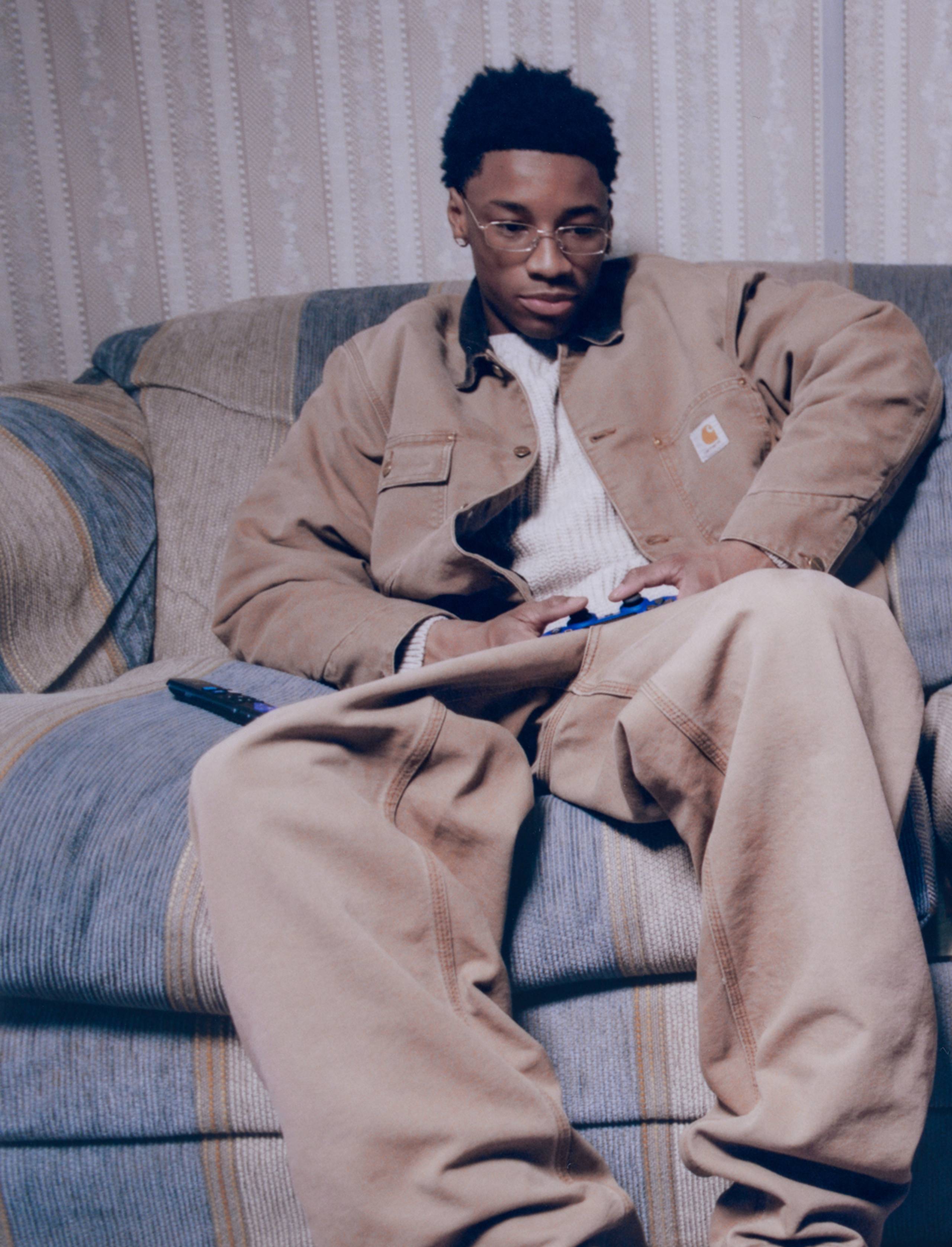 Models sitting on a couch wearing Carhartt WIP items in the Fall 2025 Campaign shot by Dan Regan