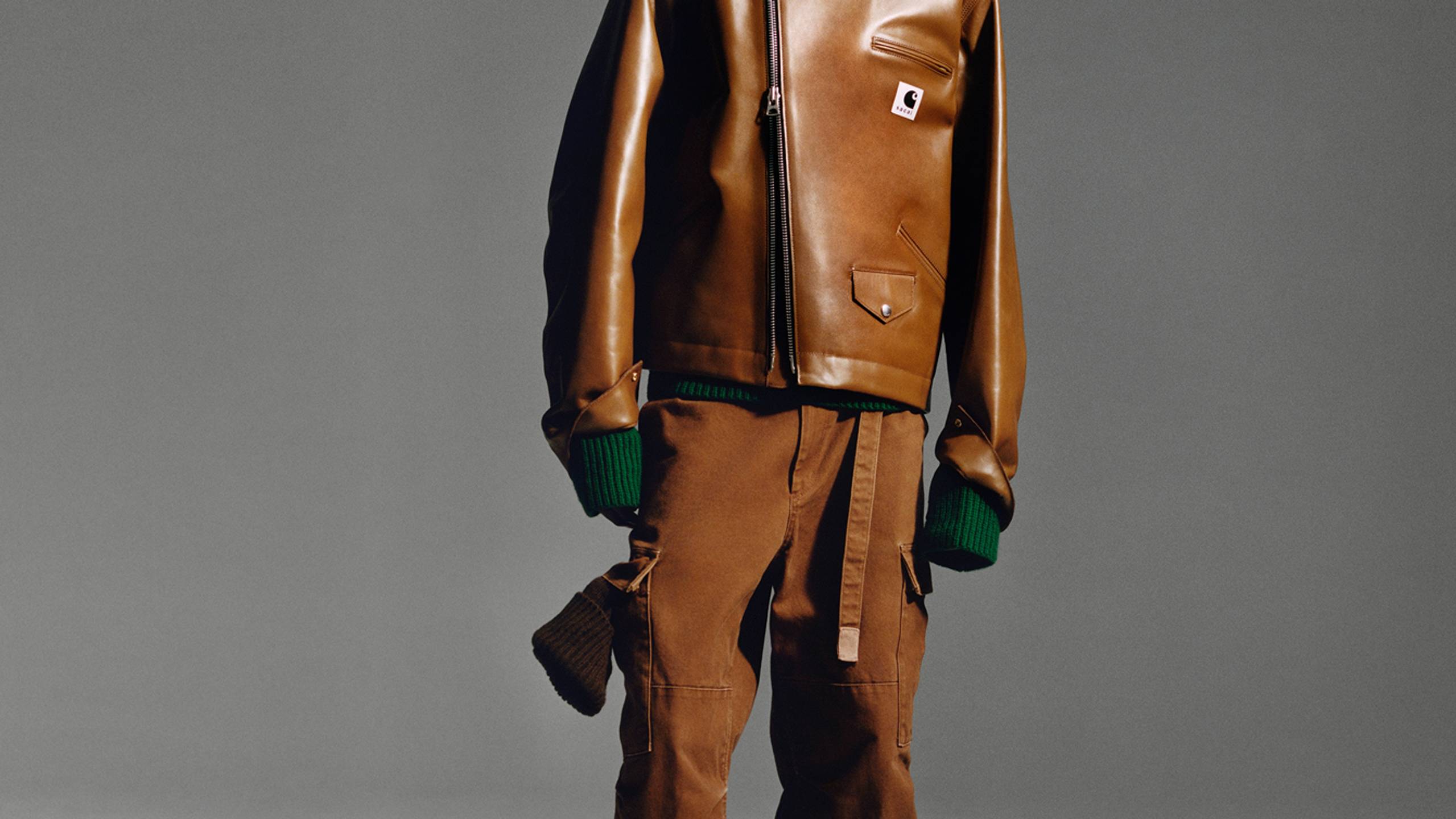 Person wearing a brown sacai x Carhartt WIP zip up leather jacket and brown pants