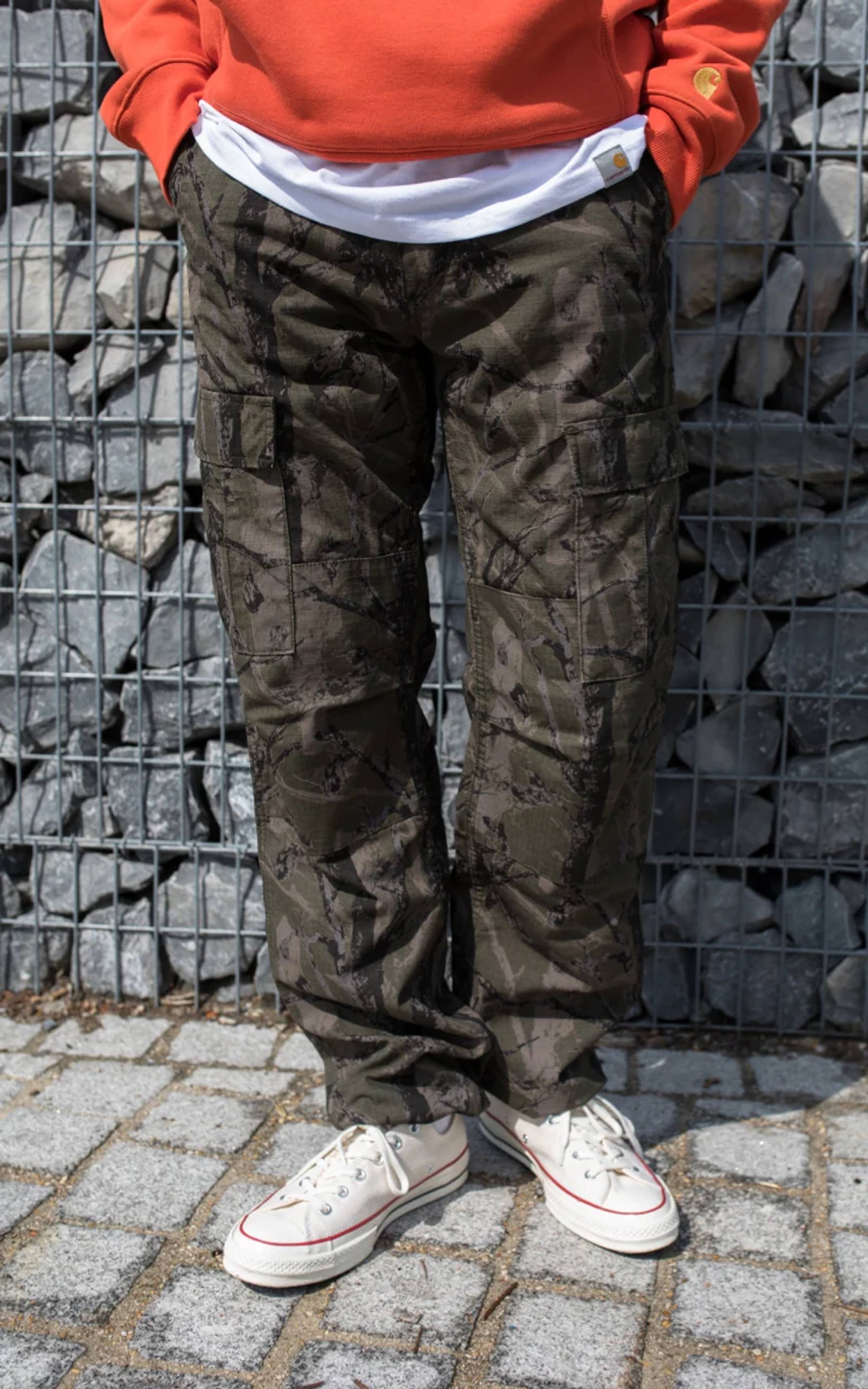 Model wearing dark camo Carhartt WIP cargo pants