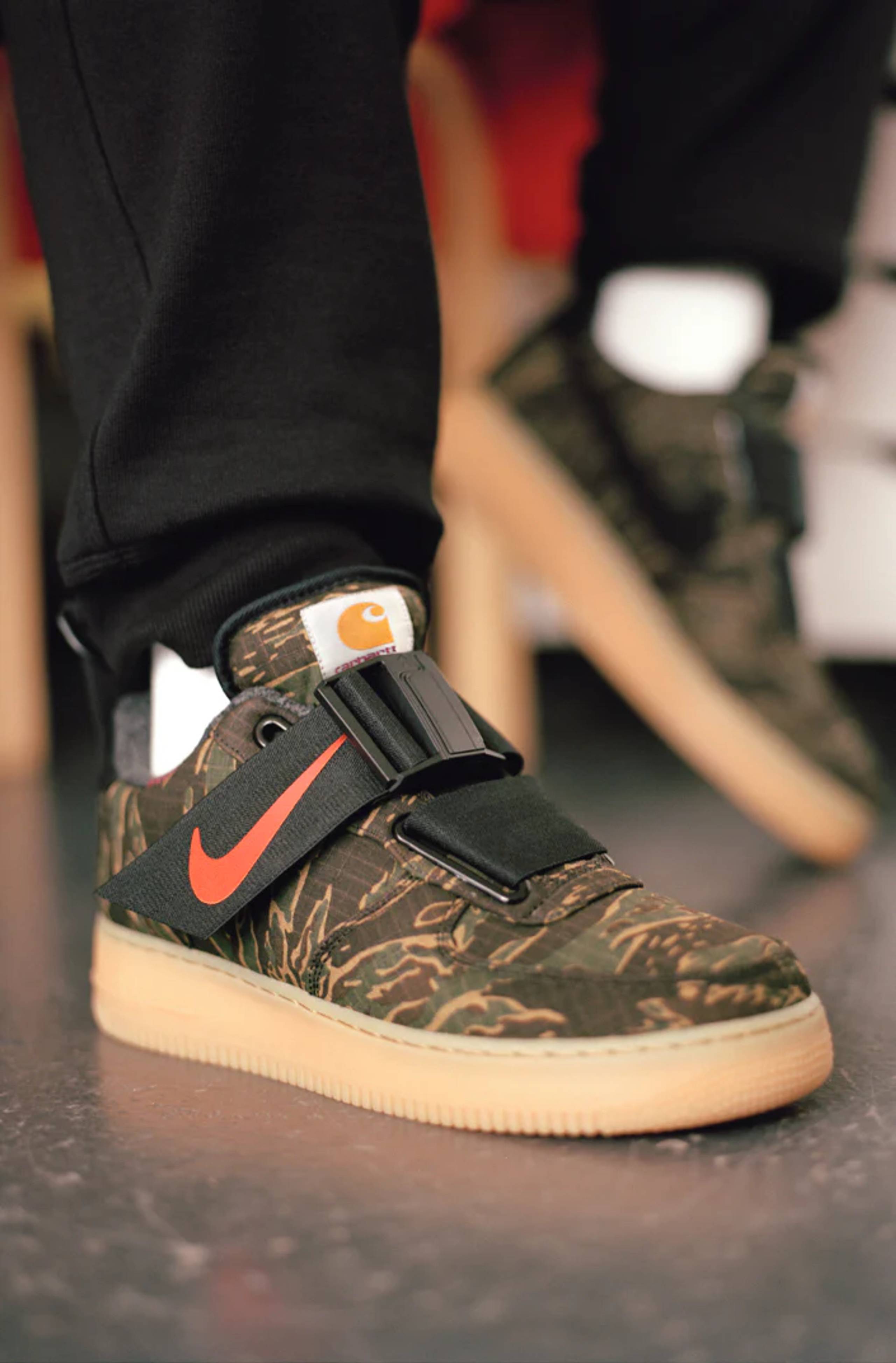 Model wearing Camo Carhartt WIP x Nike Air Force One Utility sneakers