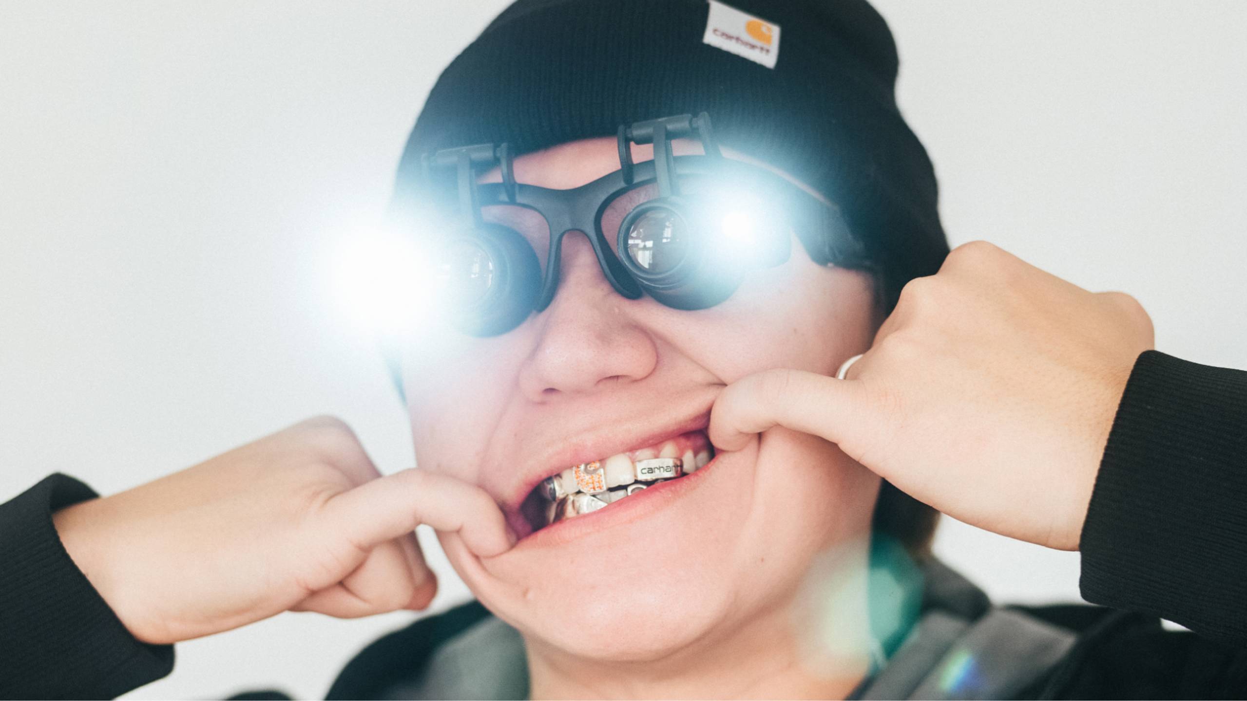 Photo of designer Eric Wu showing is gold grill in jewelry design goggles