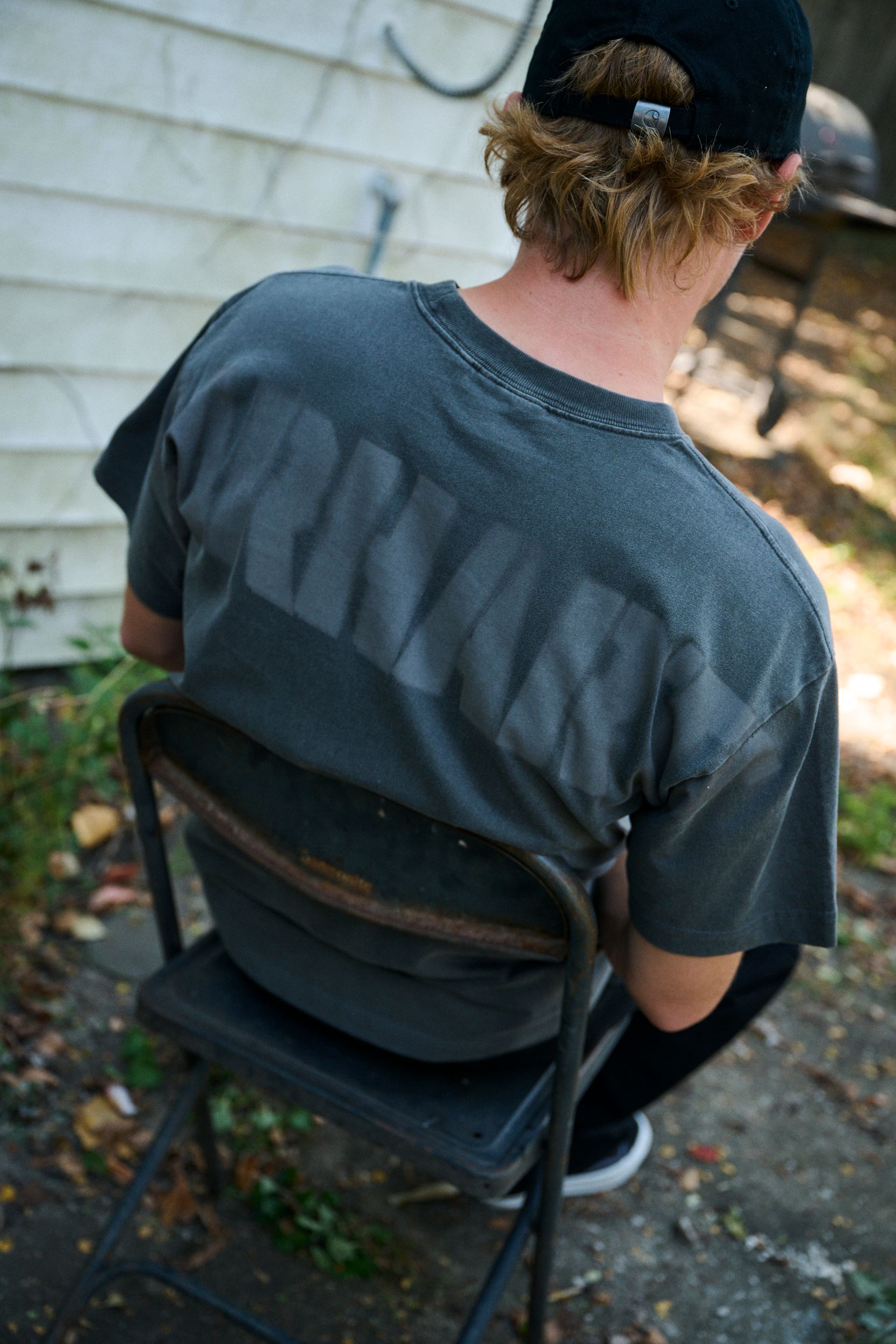 Skater sitting on a chair wearing a  RGGD T-Shirt