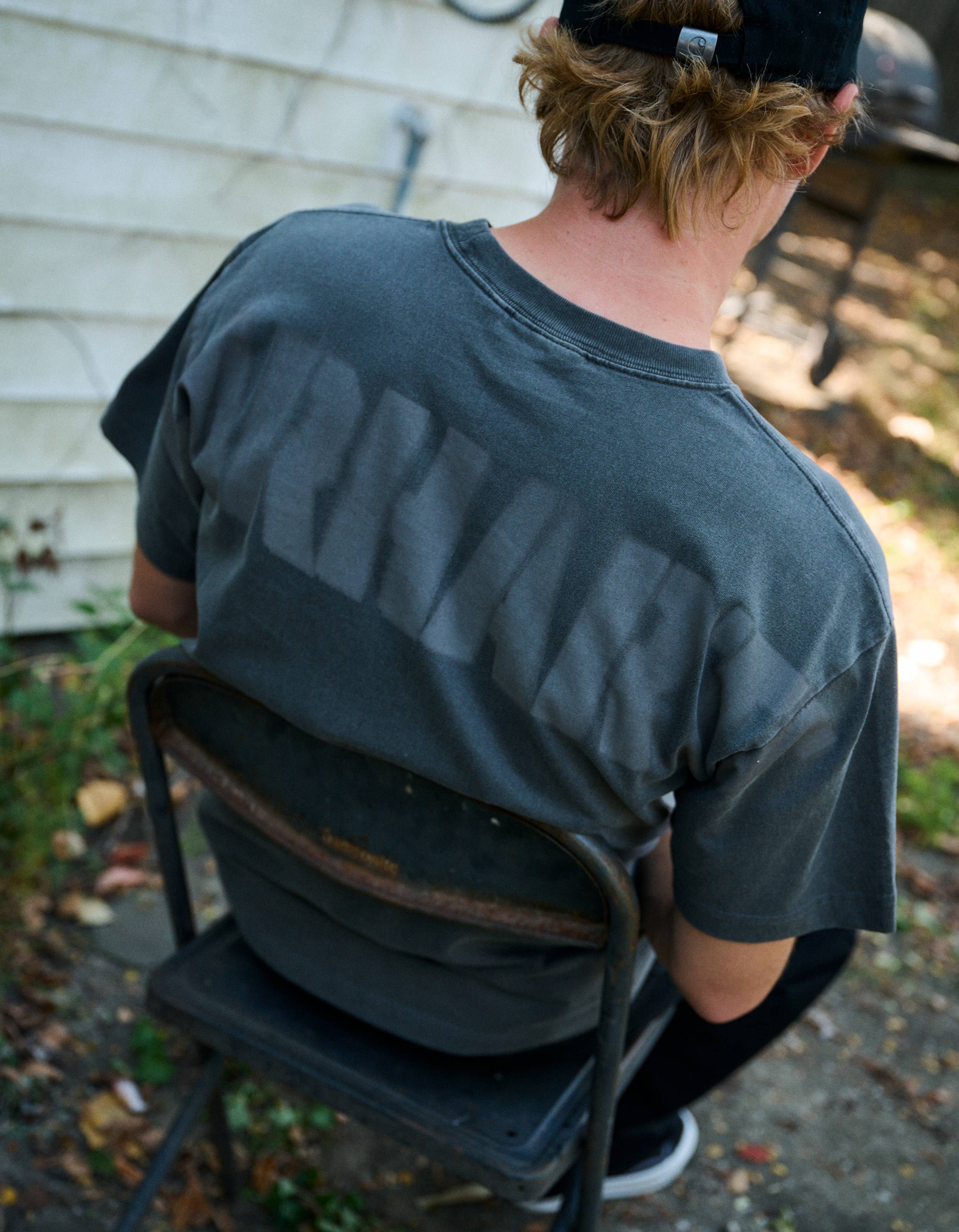 Skater sitting on a chair wearing a  RGGD T-Shirt