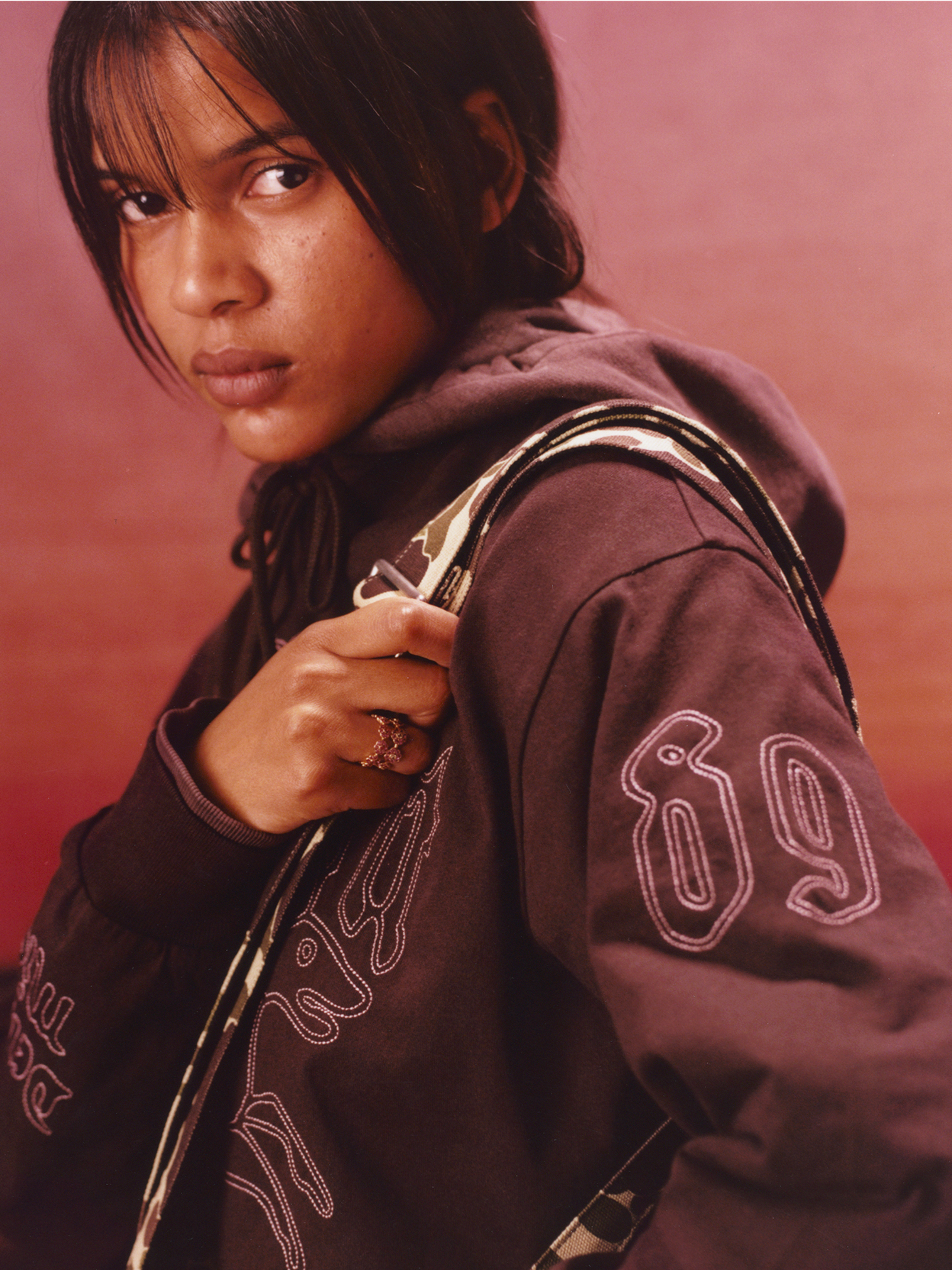 Model wearing an embroidered hooded jacket in the Carhartt WIP F/W25 Women's Lookbook