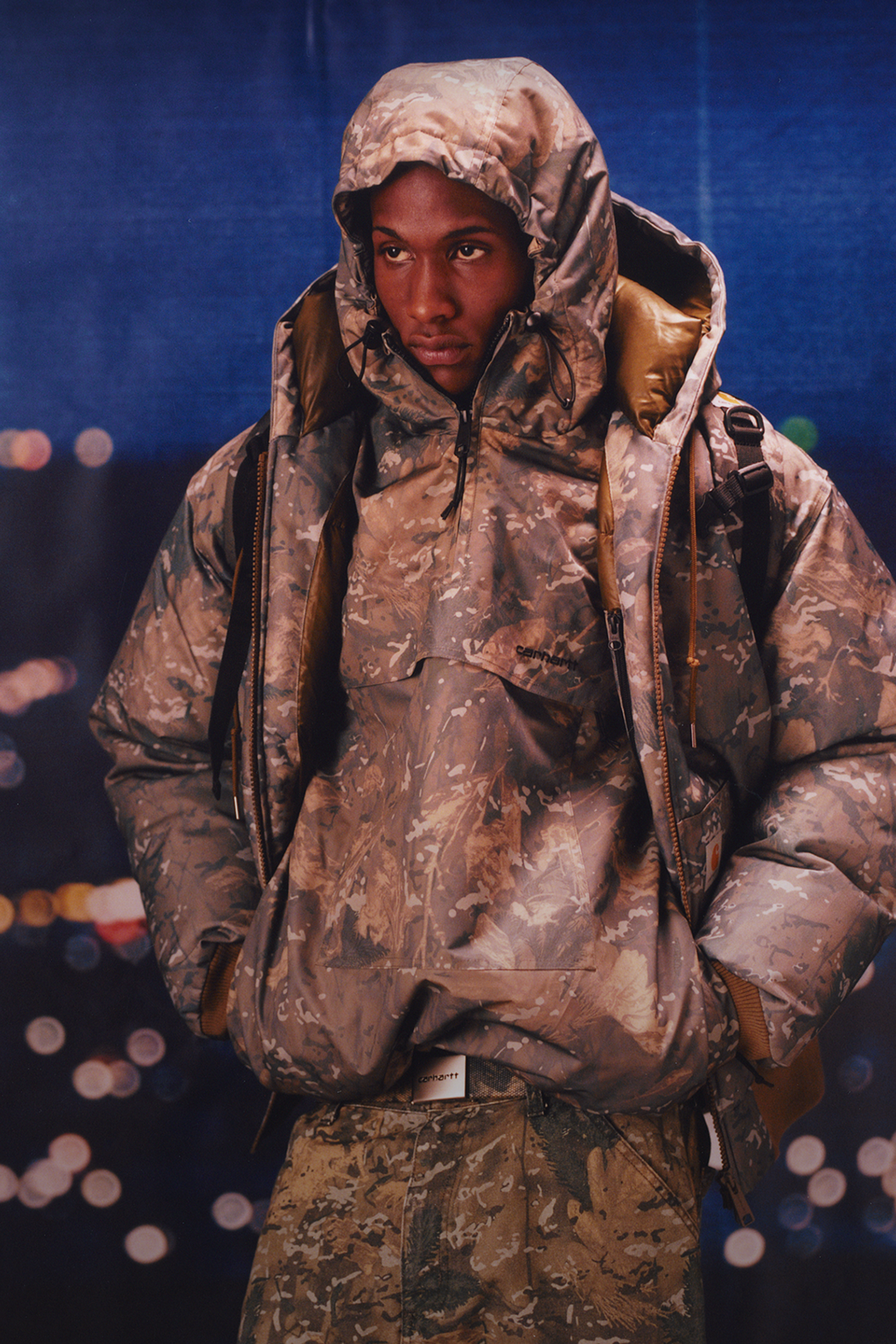 Model wearing an all camo outfit in the Carhartt WIP F/W25 Men's Lookbook
