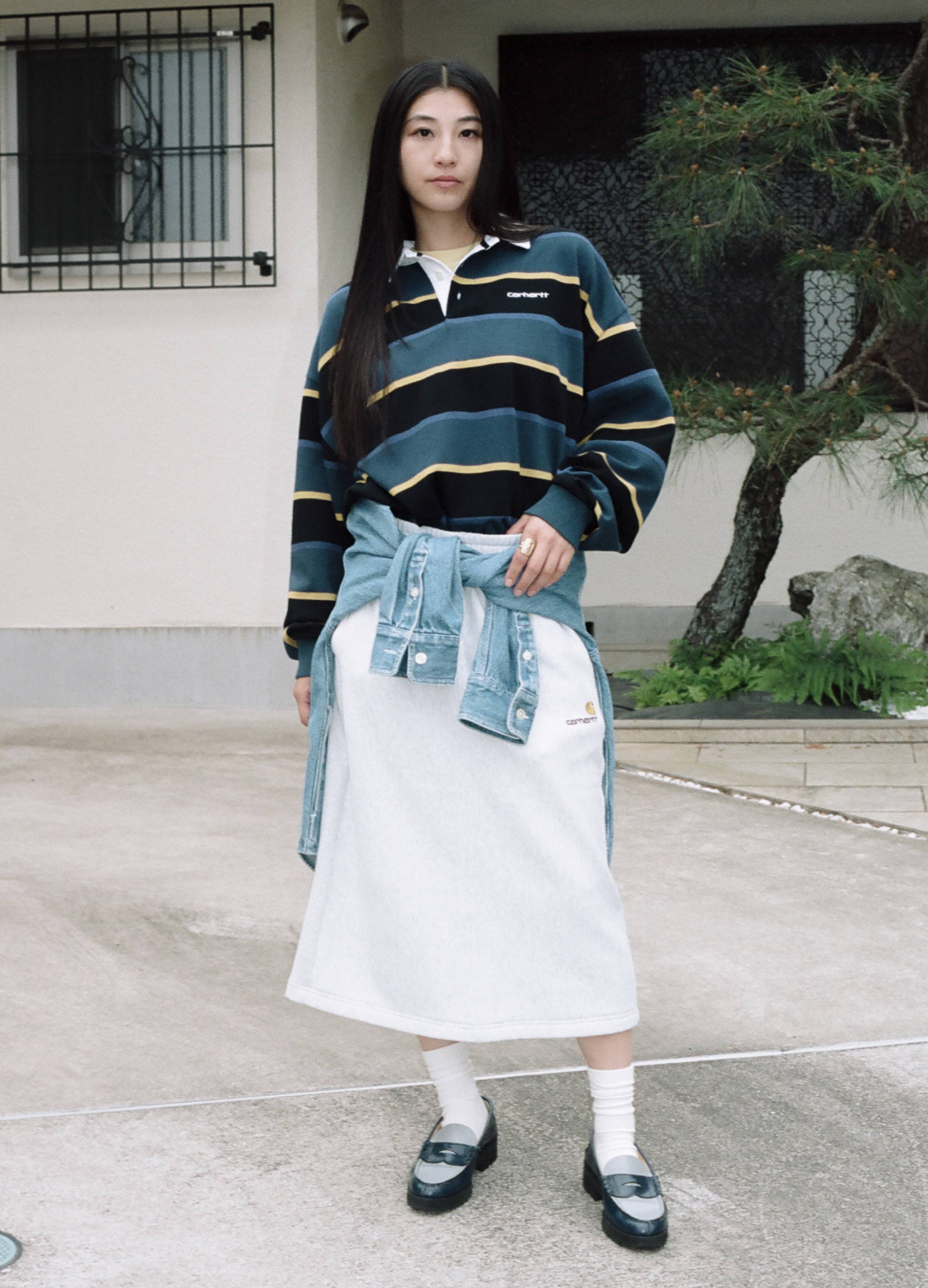 Model wearing a L/S Archie Polo and a denim shirt wrapped around her waist from the S/S25: Store Exclusives Collection