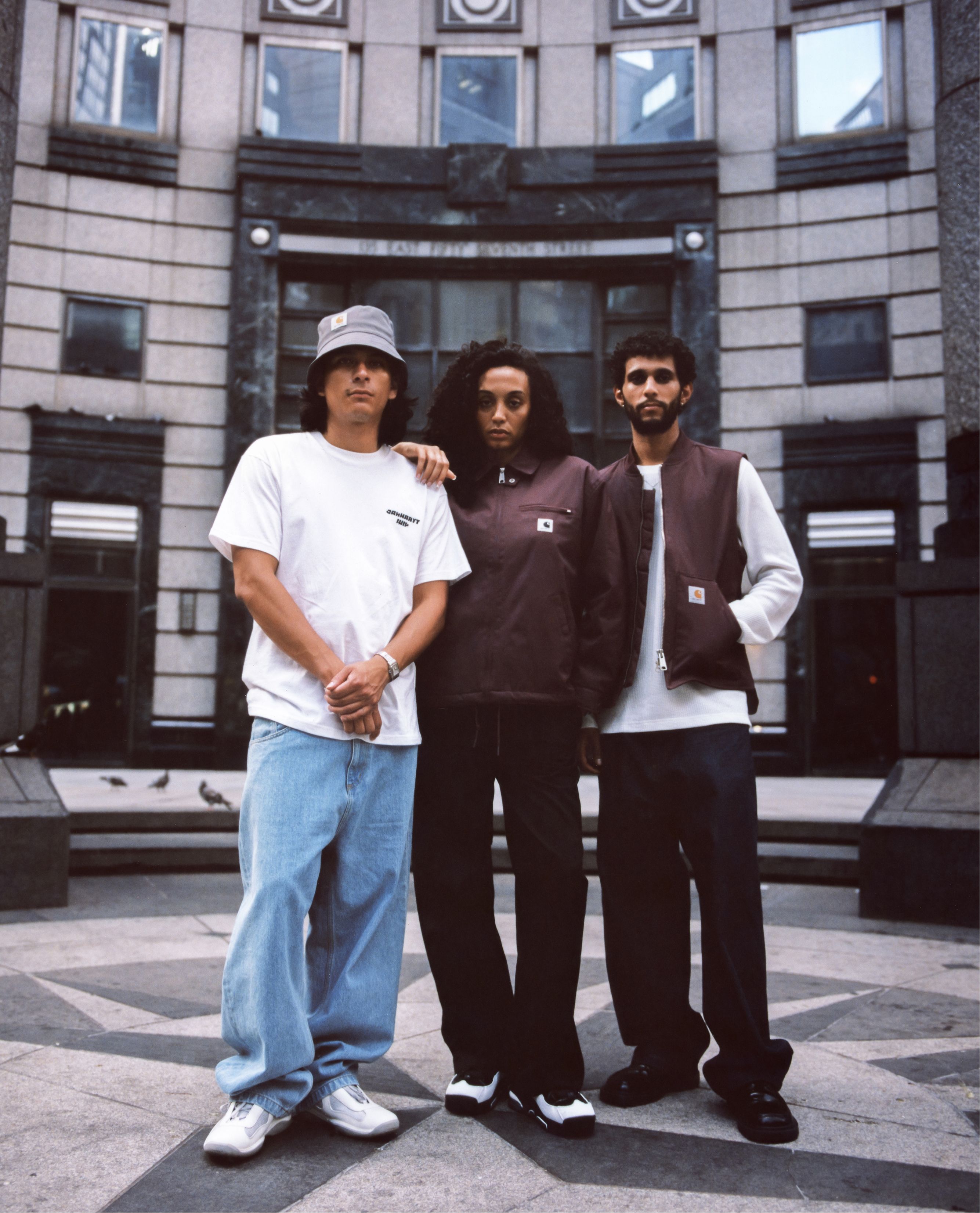 Group shot of models standing in front of city building wearing items from the Carhartt WIP Wiptopia Collection