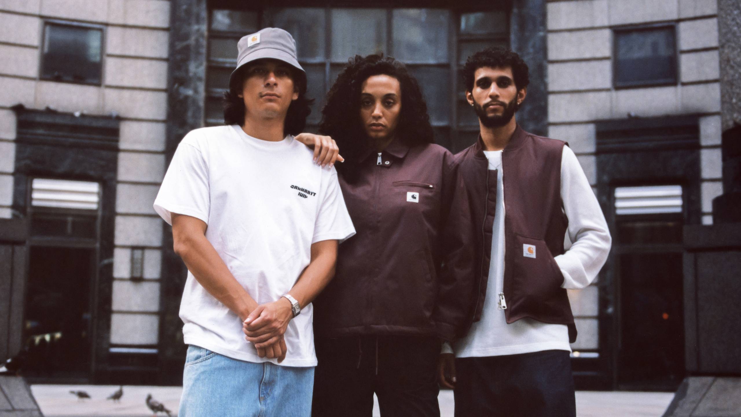 Group shot of models standing in front of city building wearing items from the Carhartt WIP Wiptopia Collection