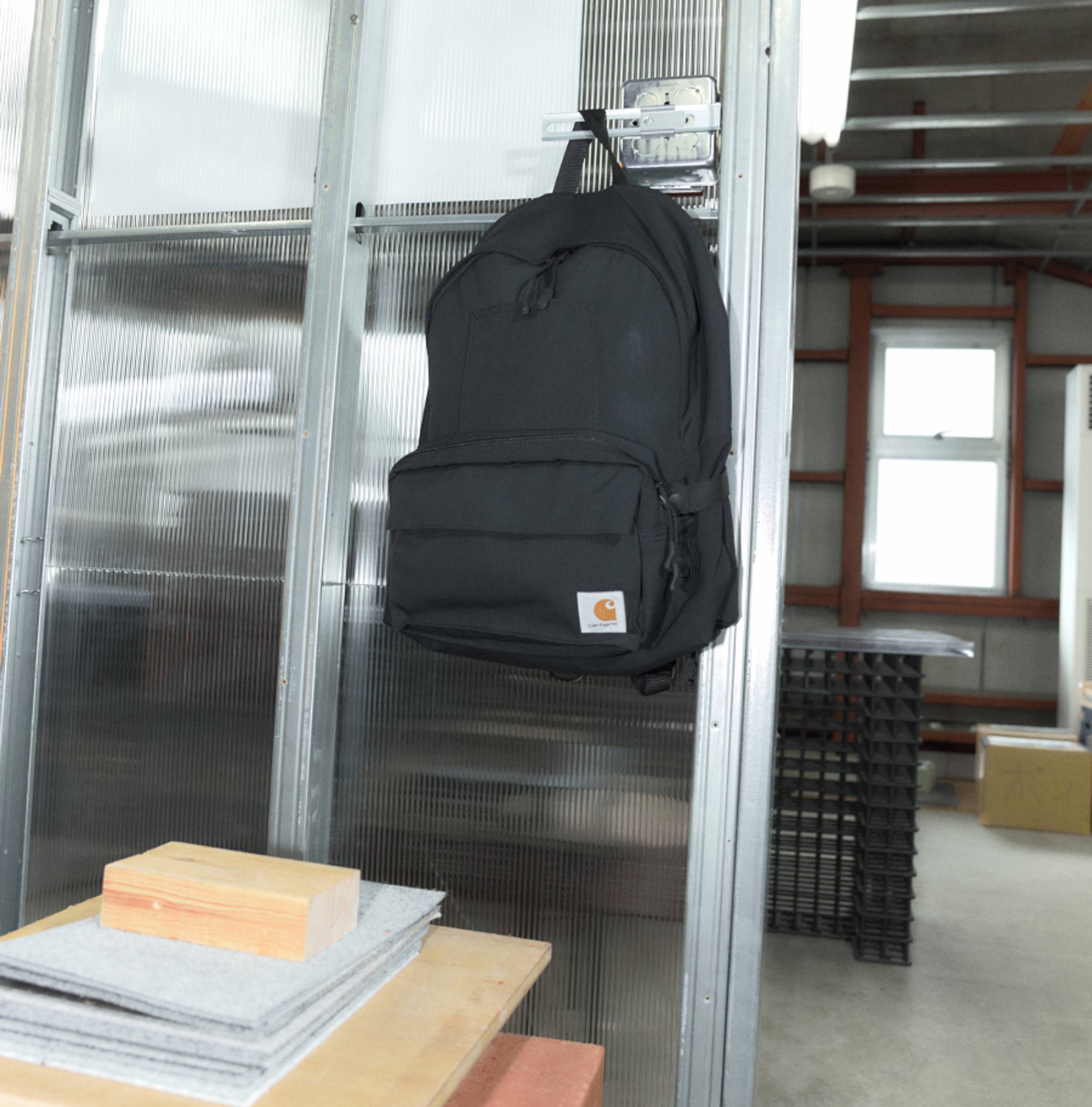 Black Carhartt WIP x INVINCIBLE® Detachable Backpack hanging in office