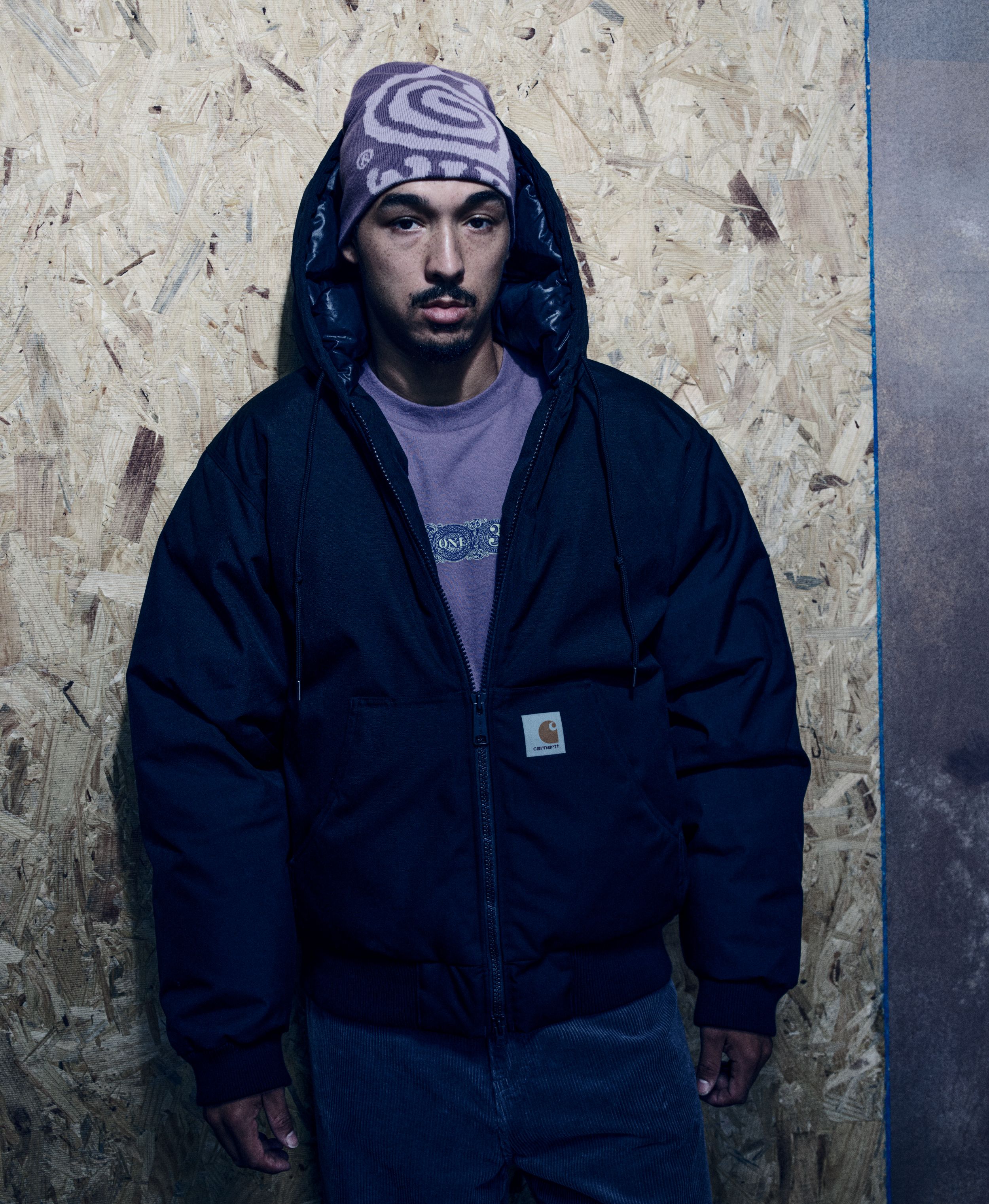 Model wearing an OG Active Cold Jacket in Black and a Helix Beanie in Phlox / Pink Fog