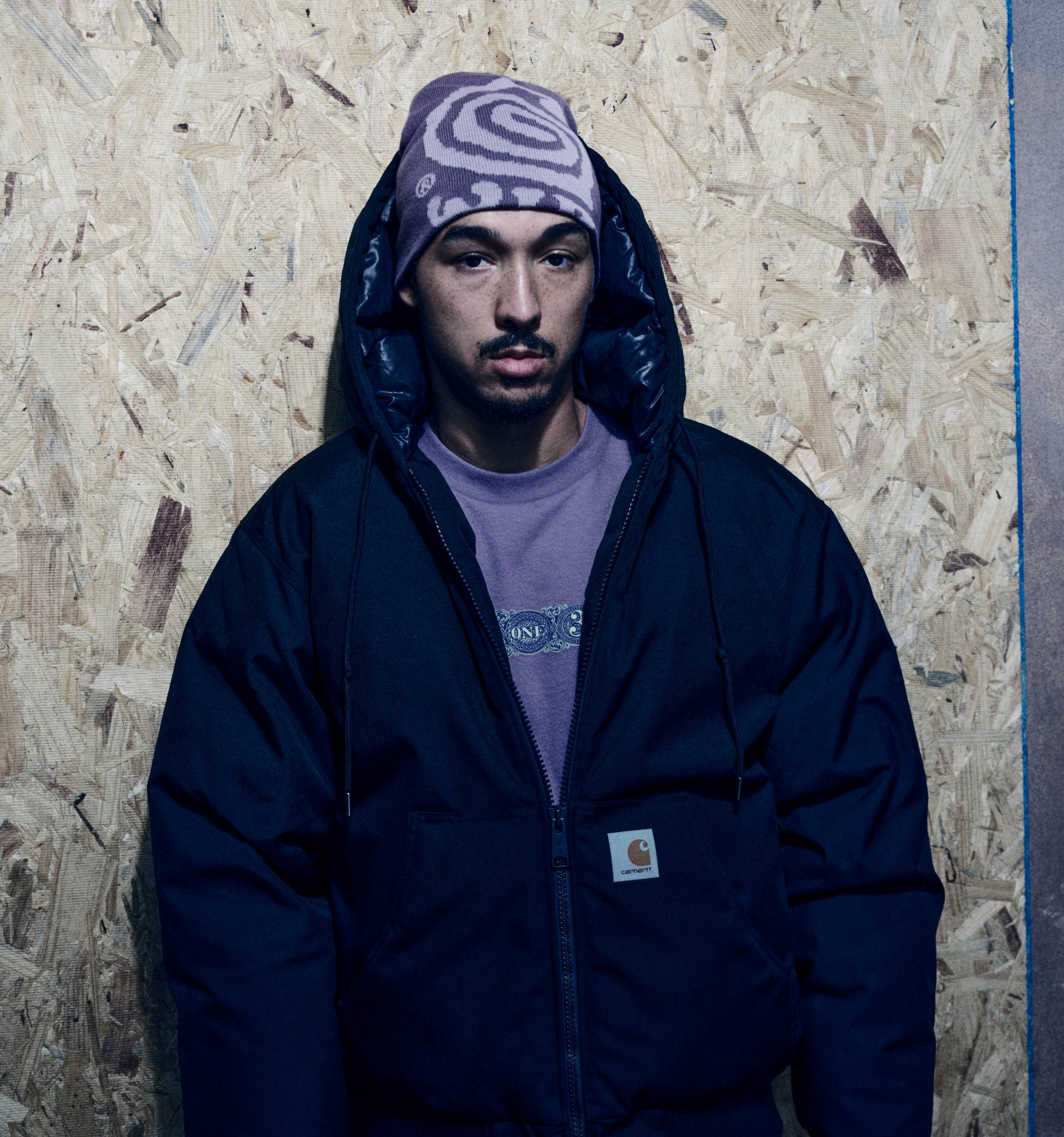 Model wearing an OG Active Cold Jacket in Black and a Helix Beanie in Phlox / Pink Fog