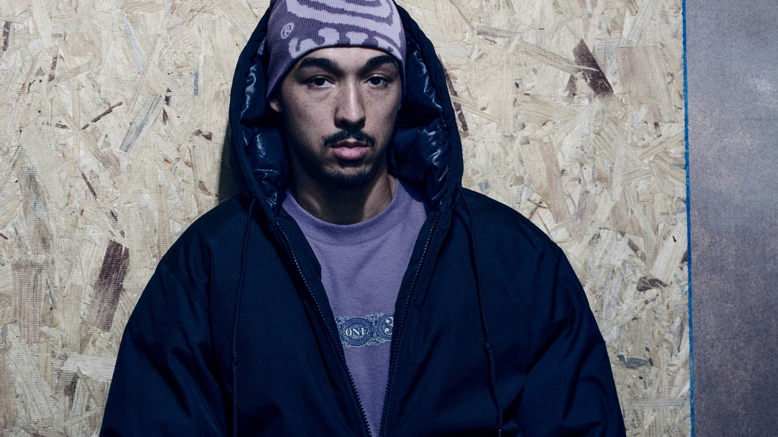 Model wearing an OG Active Cold Jacket in Black and a Helix Beanie in Phlox / Pink Fog