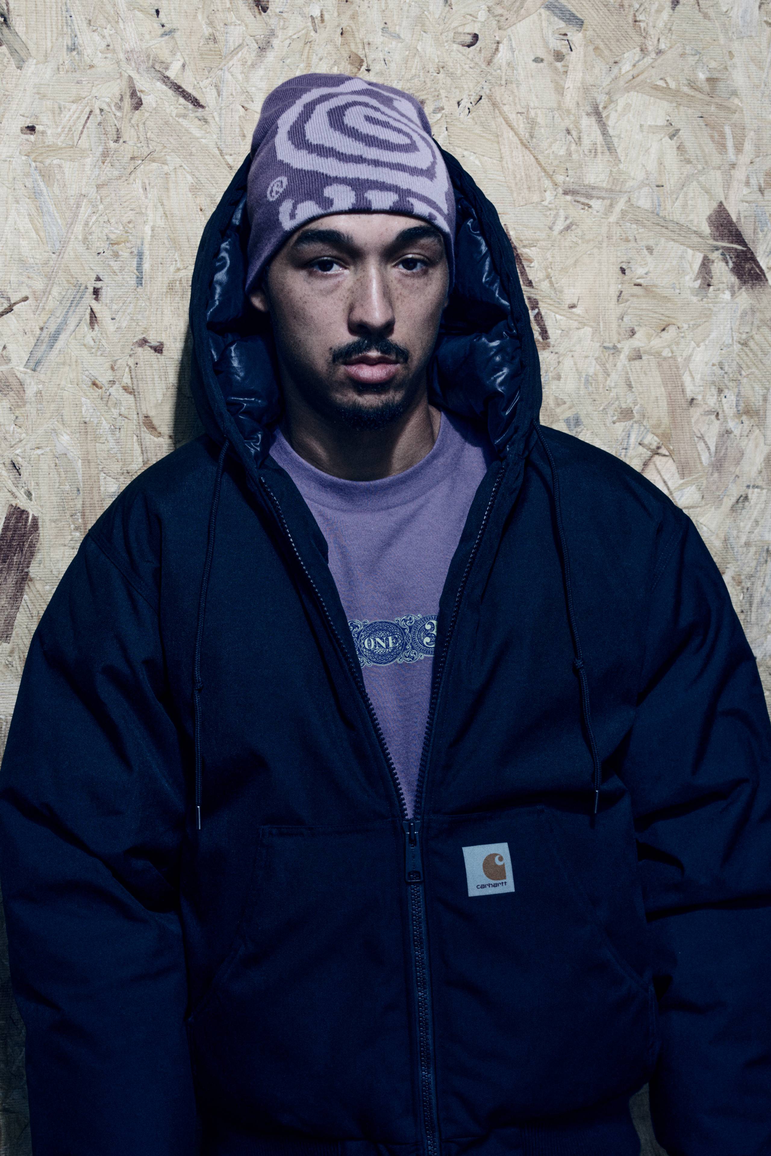 Model wearing an OG Active Cold Jacket in Black and a Helix Beanie in Phlox / Pink Fog