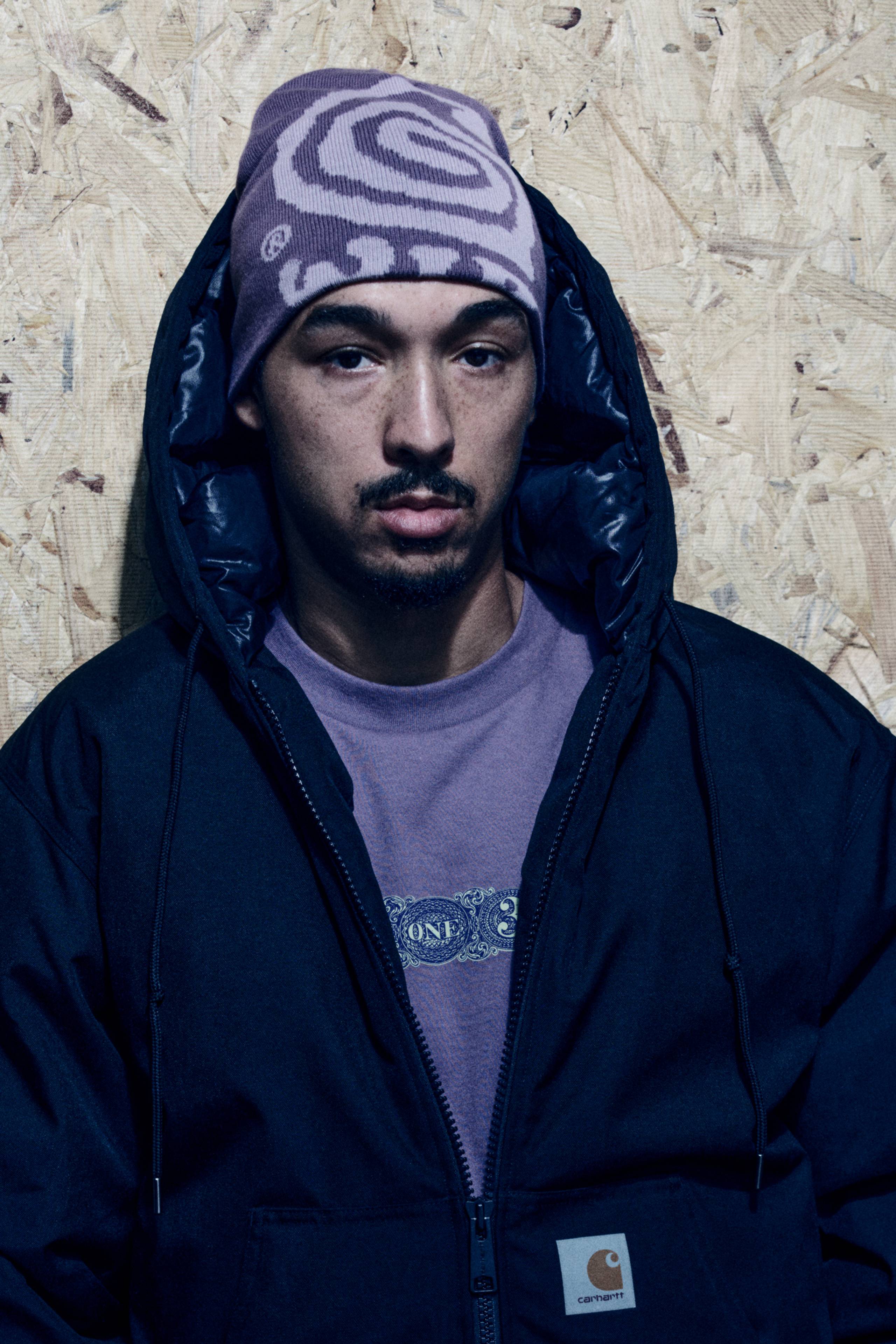 Model wearing an OG Active Cold Jacket in Black and a Helix Beanie in Phlox / Pink Fog