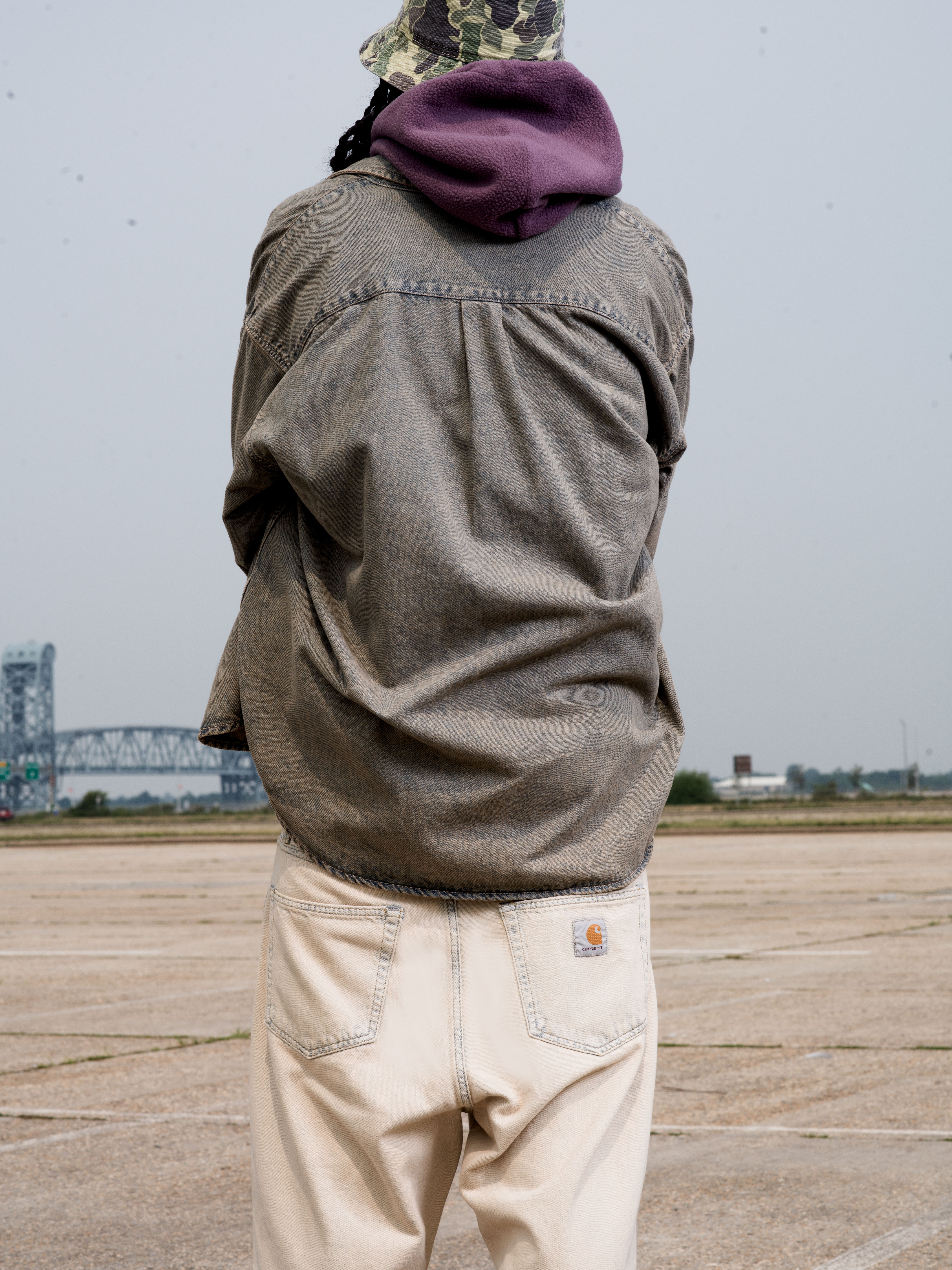 Back Shot of Model wearing a Tigan Shirt Jacket in Blue Garment Dyed and Landon Pant in Blue Sand Bleached in a parking lot