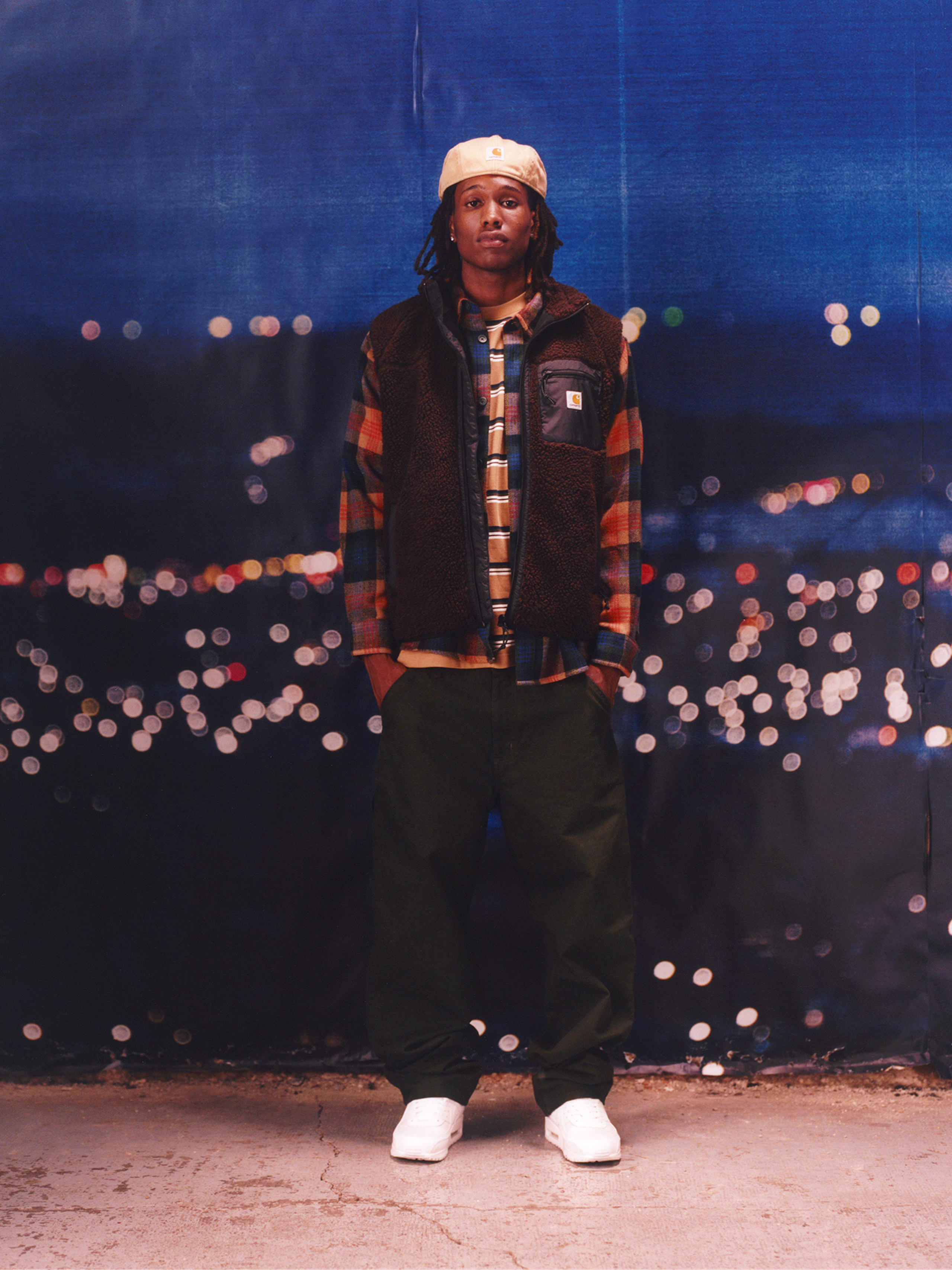 Model wearing a liner vest and plaid shirt in the Carhartt WIP F/W25 Men's Lookbook