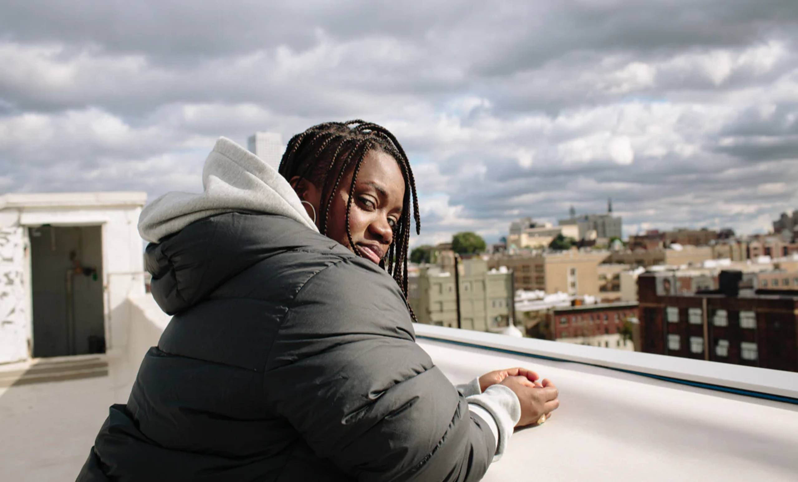 Model on rooftop wearing Carhartt WIP x Nike coat & hoodie