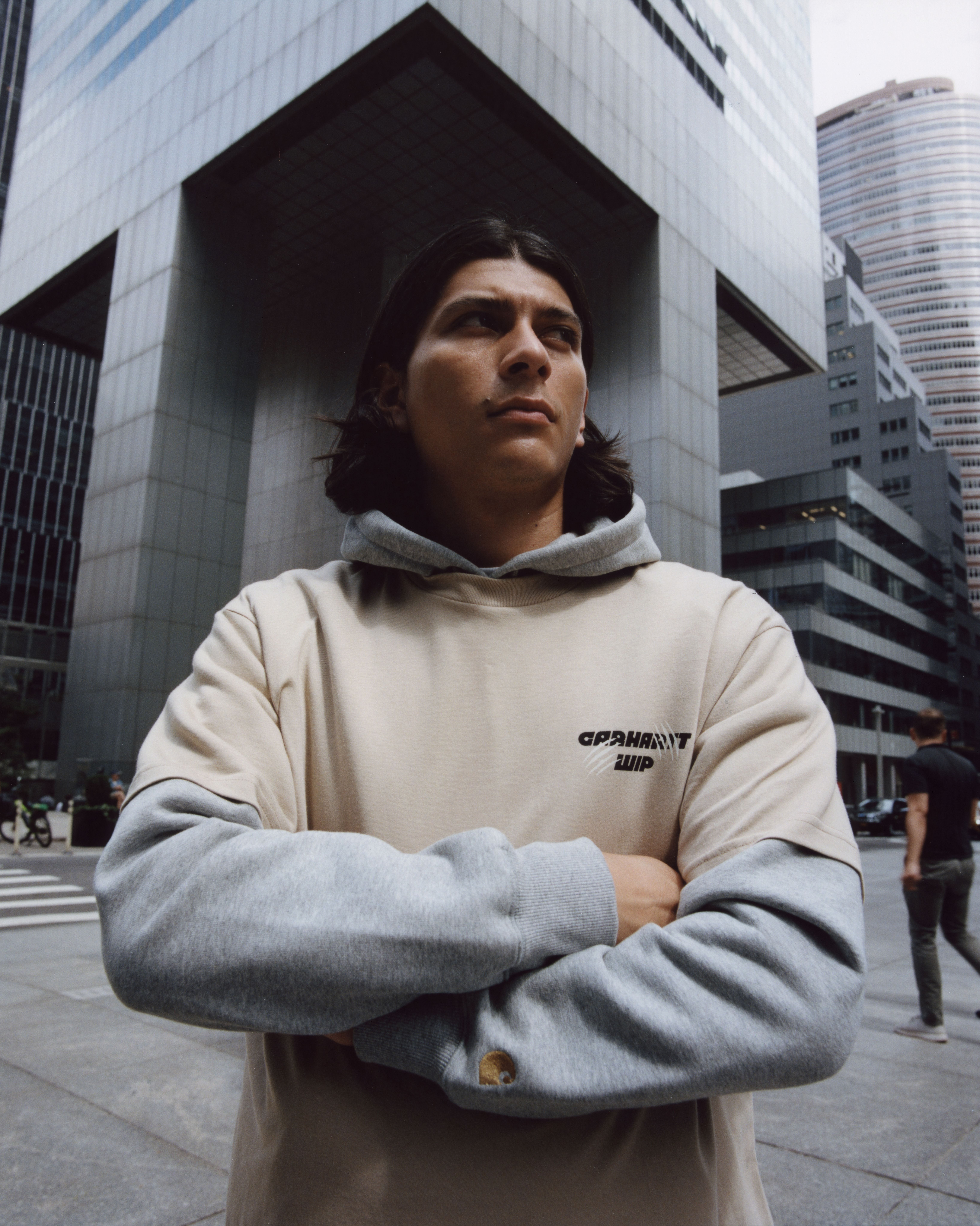 Model standing with arms crossed wearing items from the Carhartt WIP Wiptopia Collection