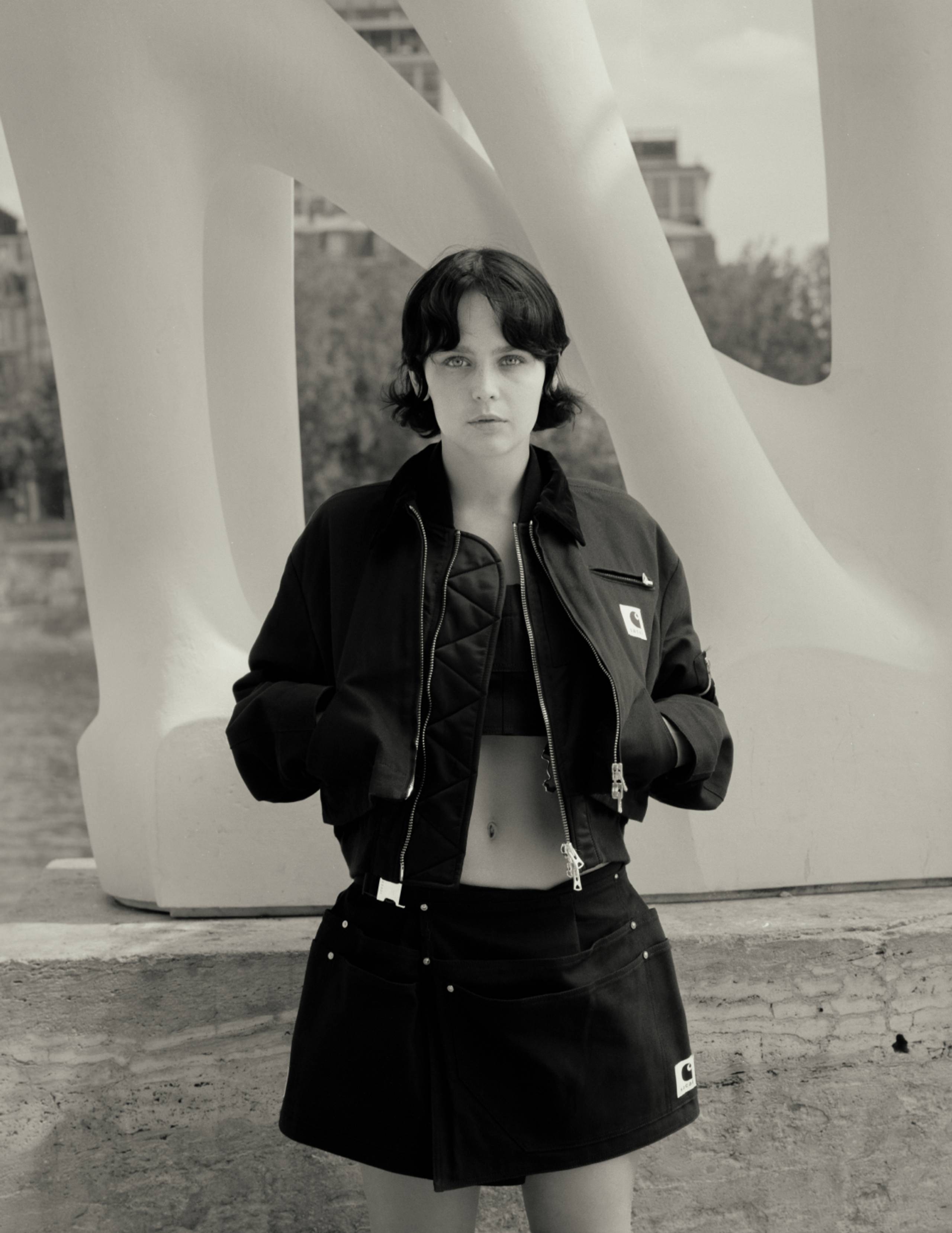 Model wearing items from the sacai x Carhartt WIP collection