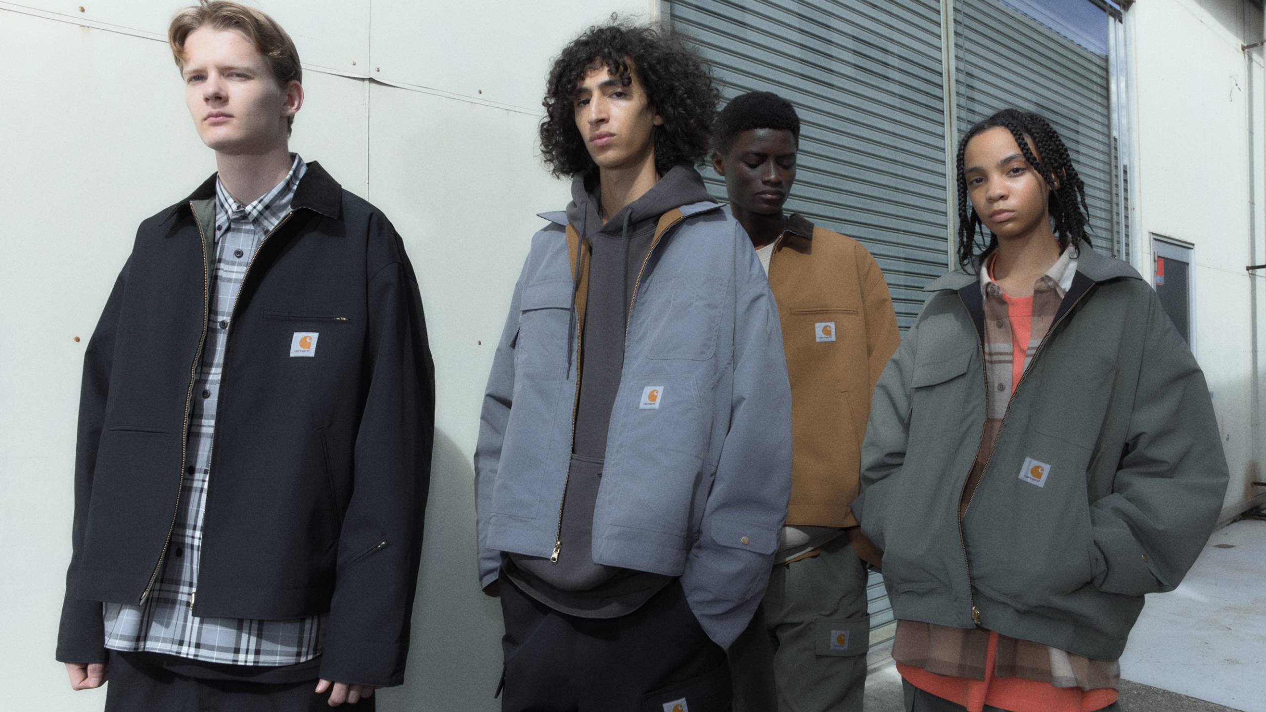 4 Models wearing items from the Carhartt WIP x INVINCIBLE® collection outside a warehouse