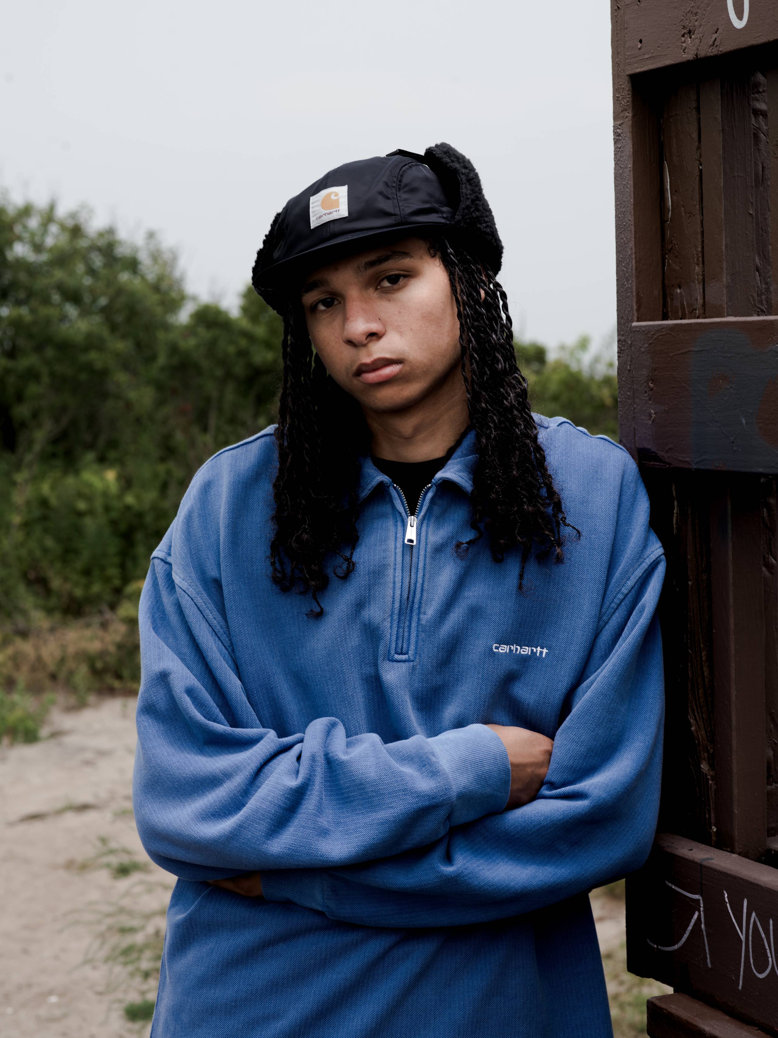 Model posing with arms crossed wearing a Pique Script Sweatshirt in Wolfsbane