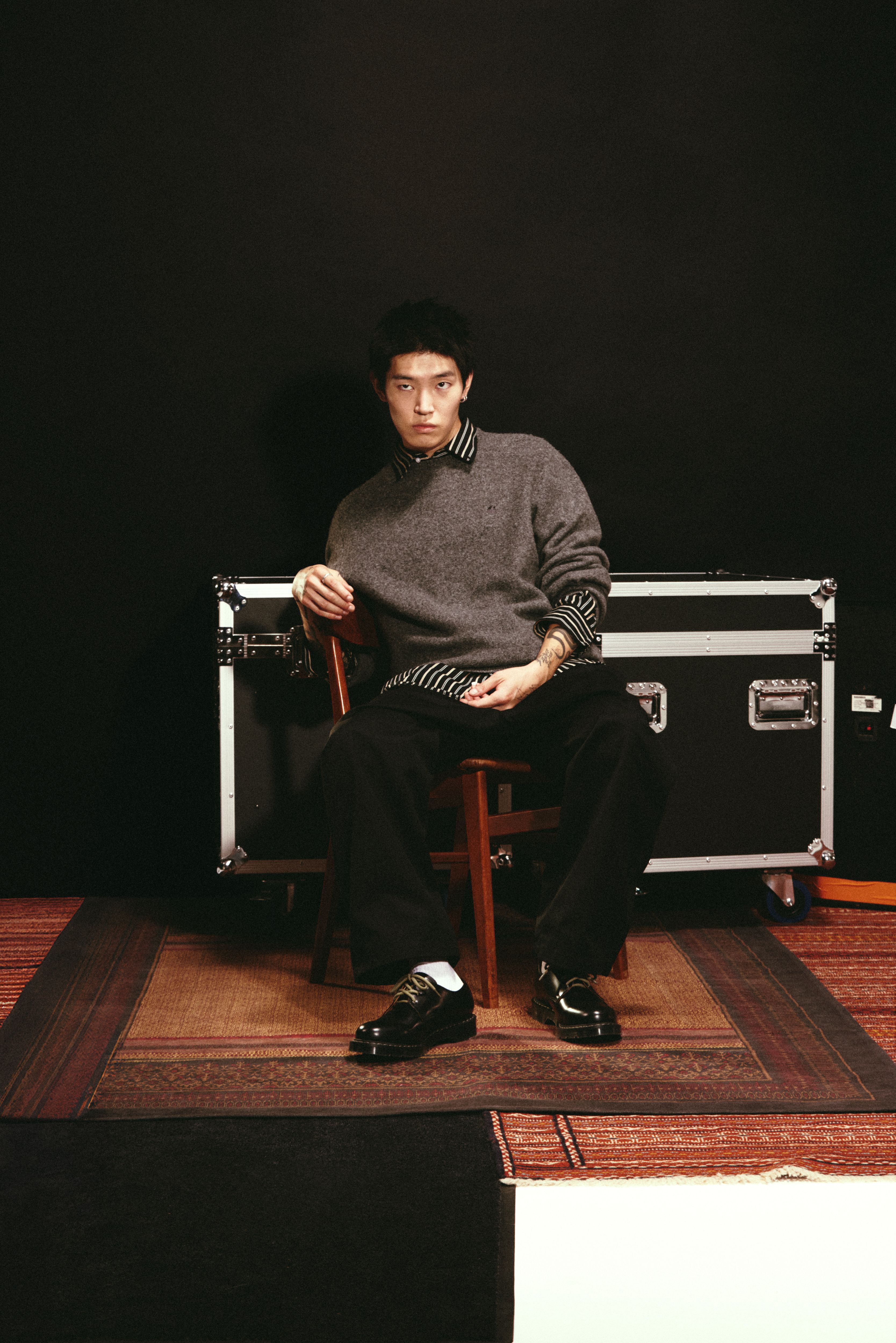 Model sitting down wearing a pair Solovair x Carhartt WIP Collaboration Derby shoes in Black