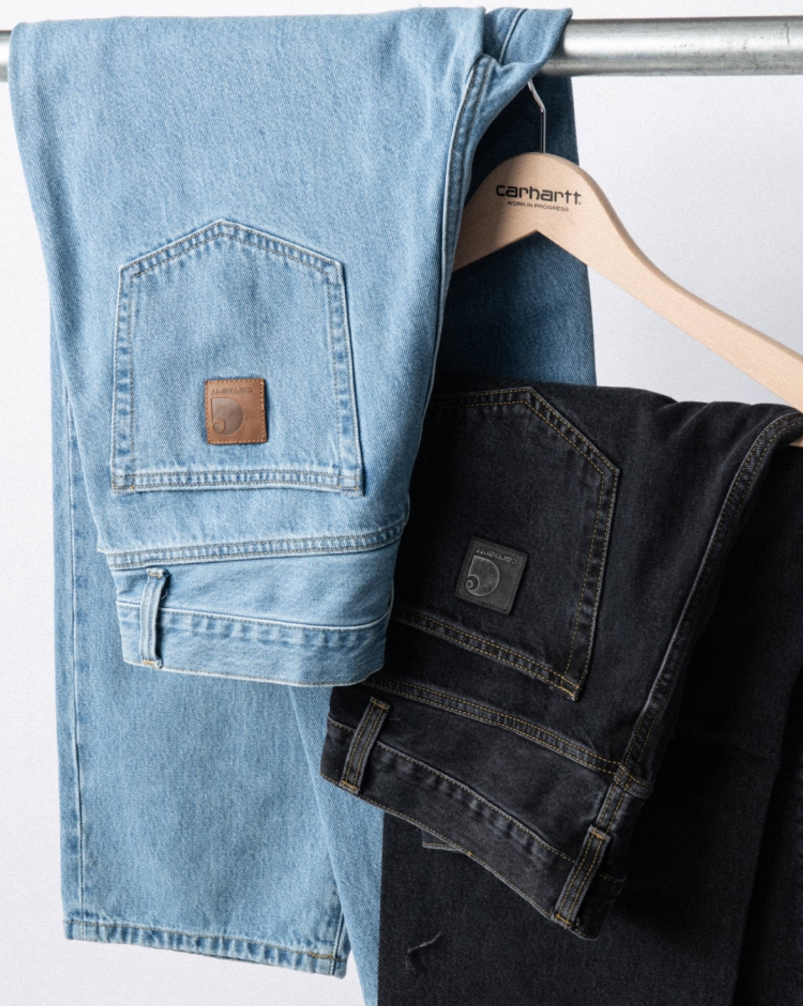 Carhartt WIP Aaron Pants in denim hanging on a hanger