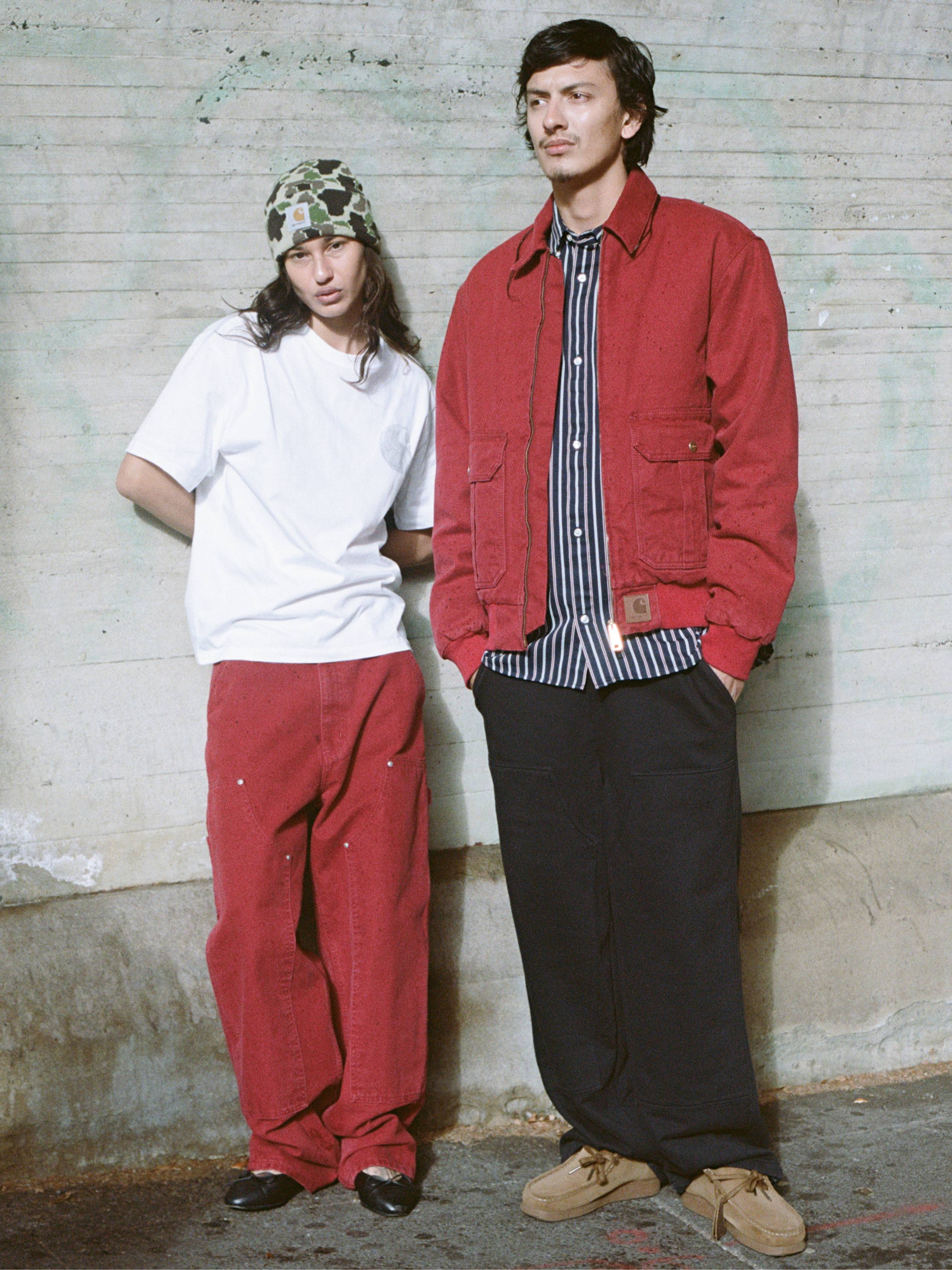Person on the left wearing red double knee pants and white t-shirt, person on the right wearing red jacket and striped shirt