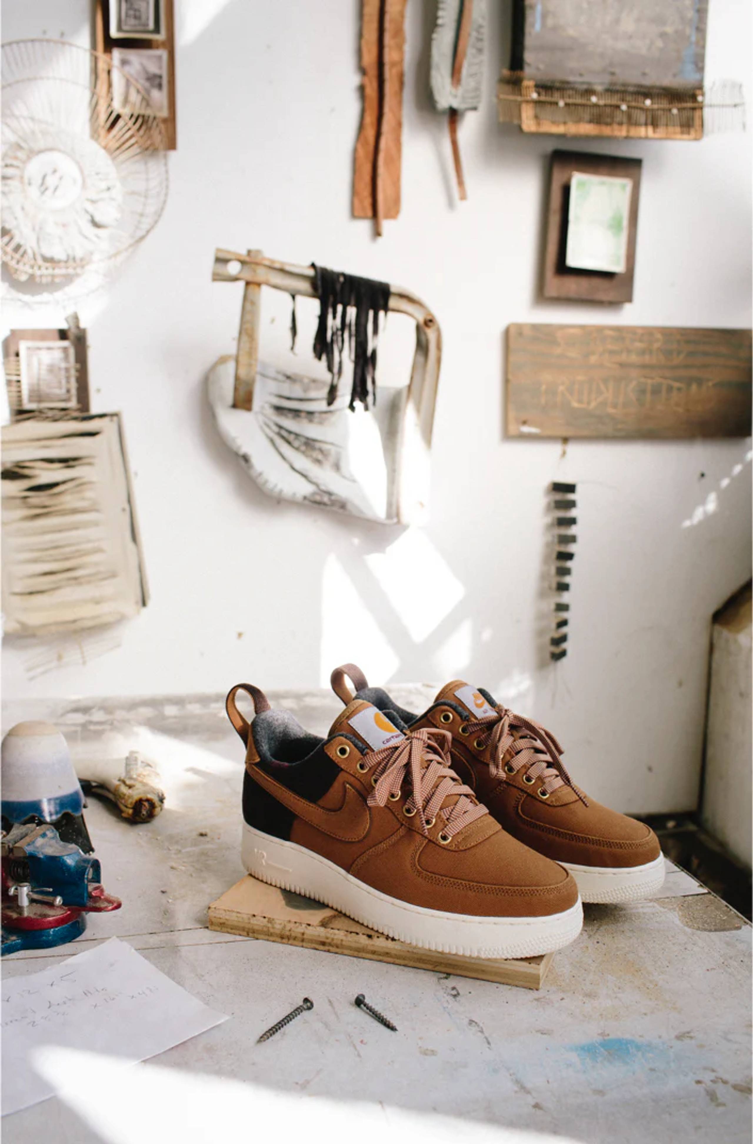 brown Carhartt WIP x Nike Air Force 1 Low sneakers on a workbench