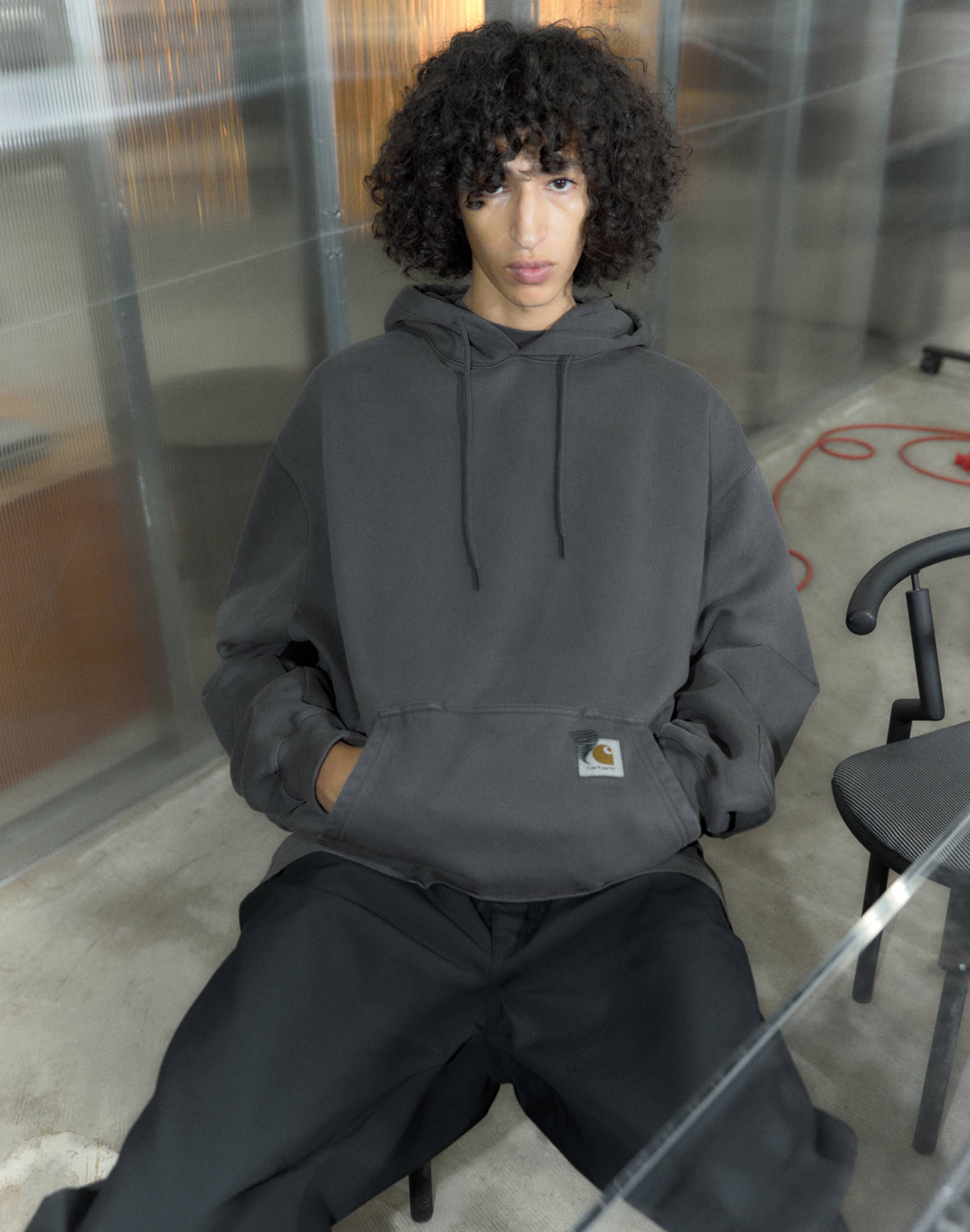 Model wearing Carhartt WIP x INVINCIBLE® grey garment dyed hoodie