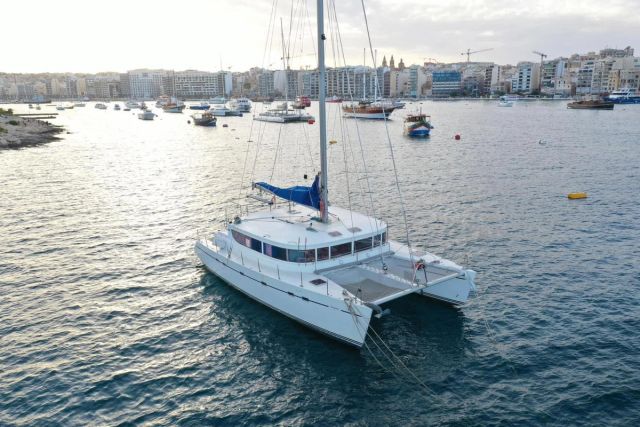 La Zingara catamaran at anchor in clear water.