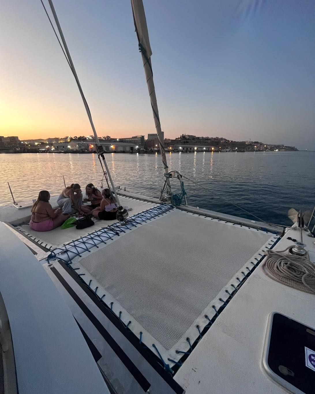 Golden-hour sunset over the sea from the deck of a catamaran off Malta.