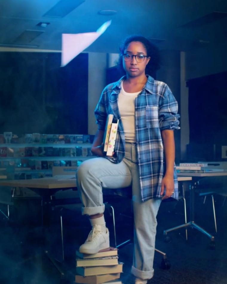 Client portrait — student with books in a library