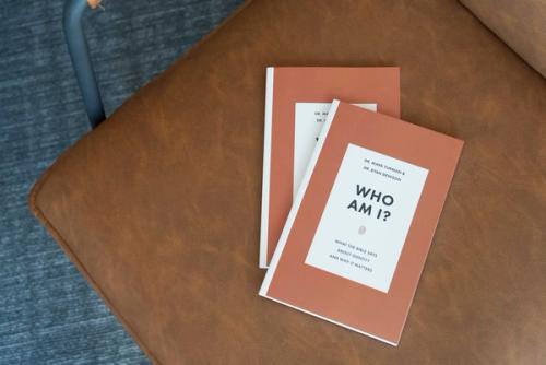 a copy of Who Am I laying on a chair