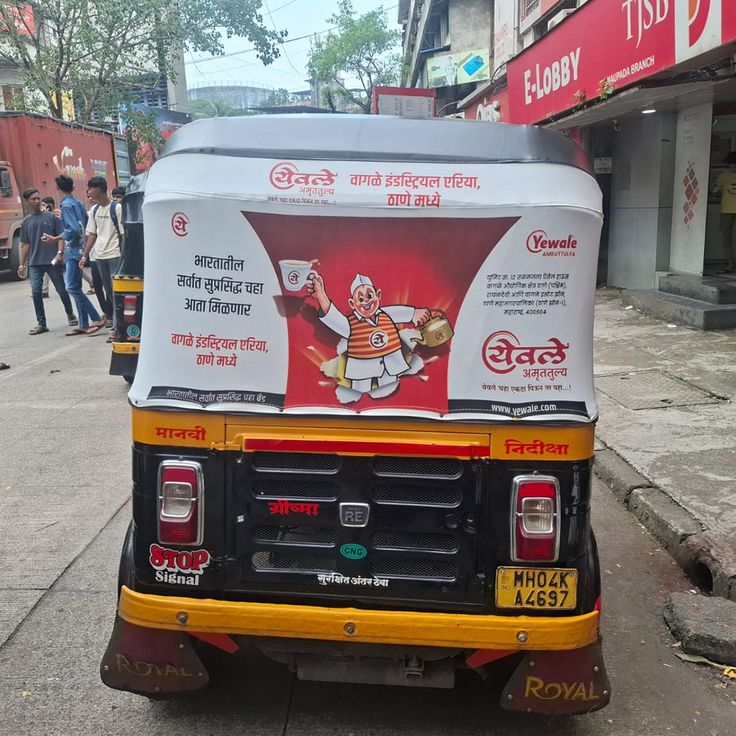 A fleet of branded auto rickshaws beside a large roadside hoarding, compared by The Mediaverse