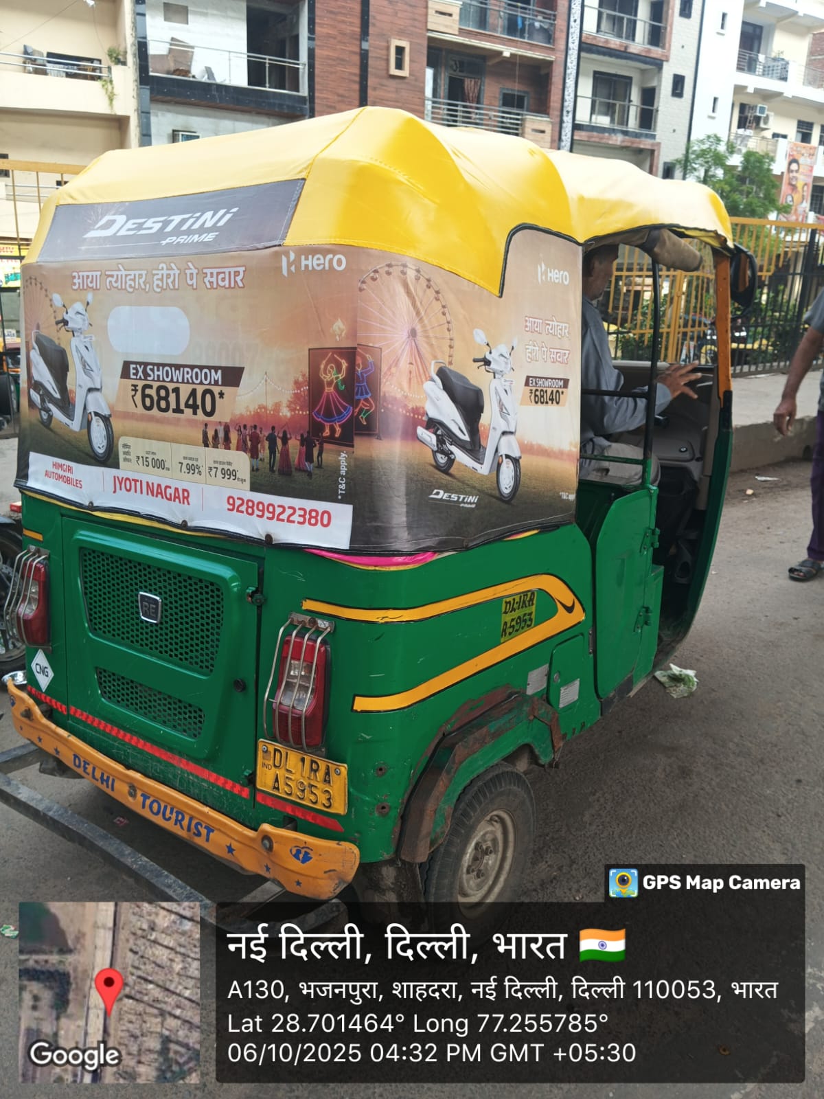 Branded CNG auto rickshaw with Gujarati-language hood advertising near a Navratri garba ground on SG Highway in Ahmedabad at night