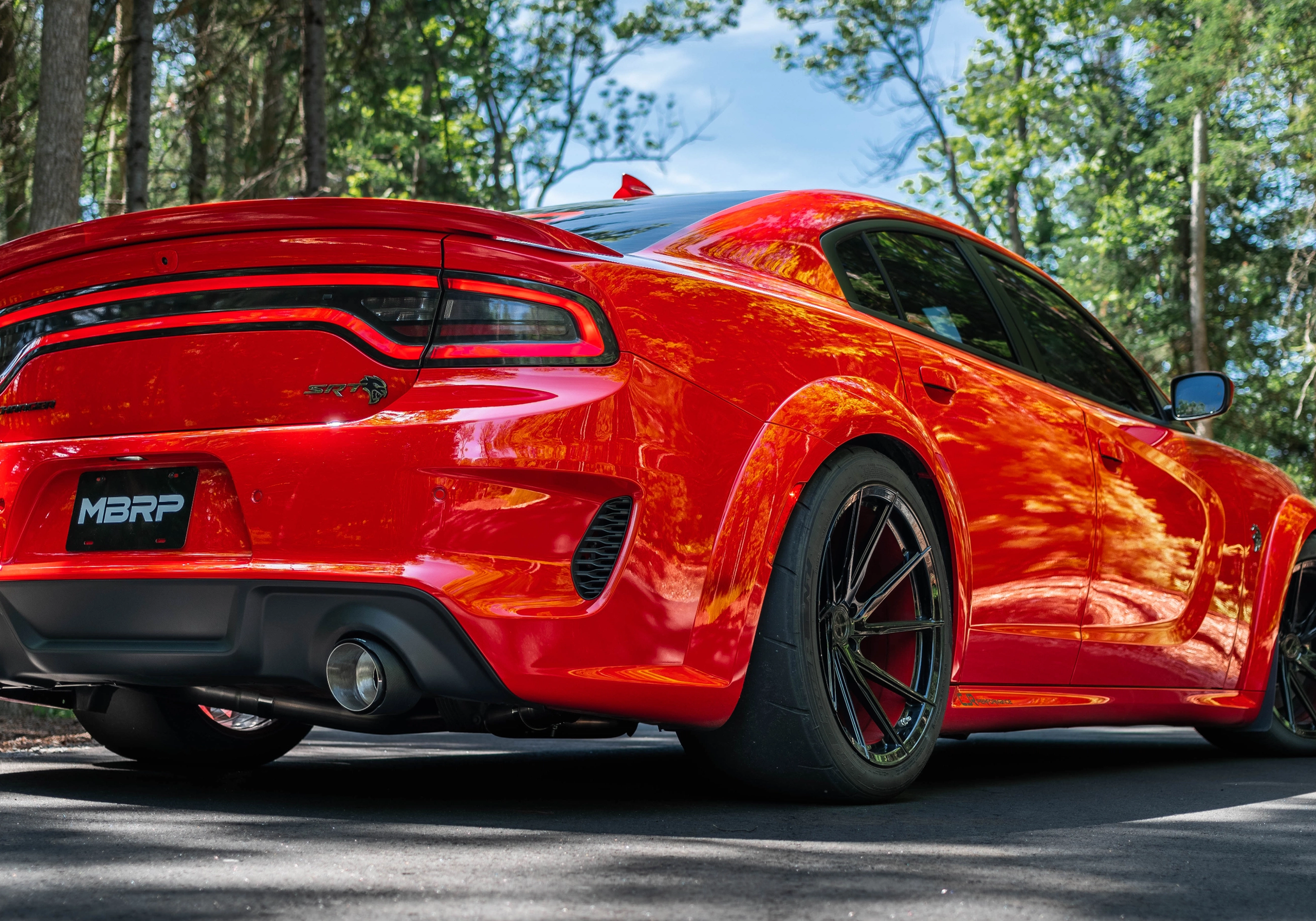 Red Dodge Charger SRT in the summer showing an mbrp exhaust installed