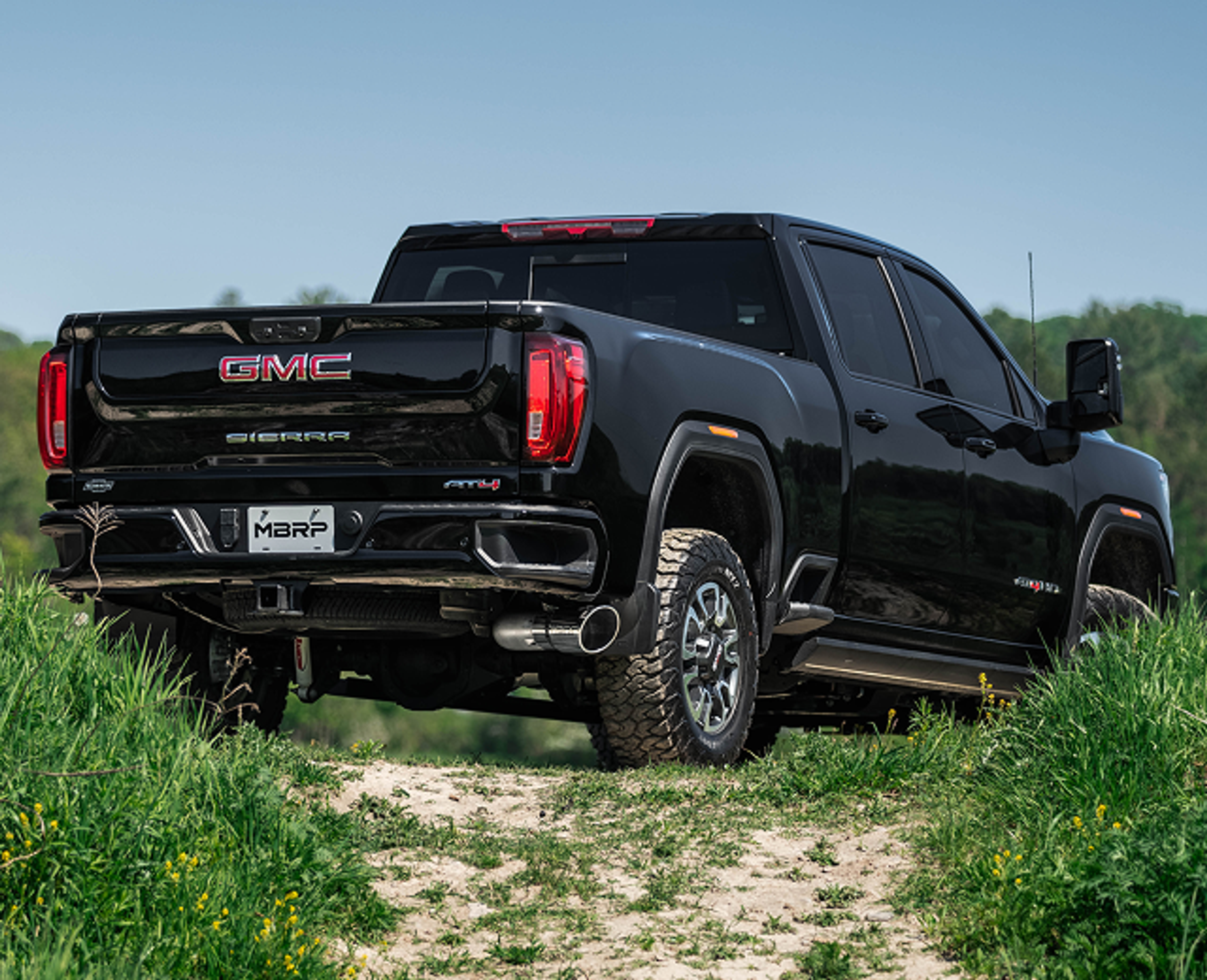 Black GMC Sierra with an mbrp exhaust installed in the sunshine in a field