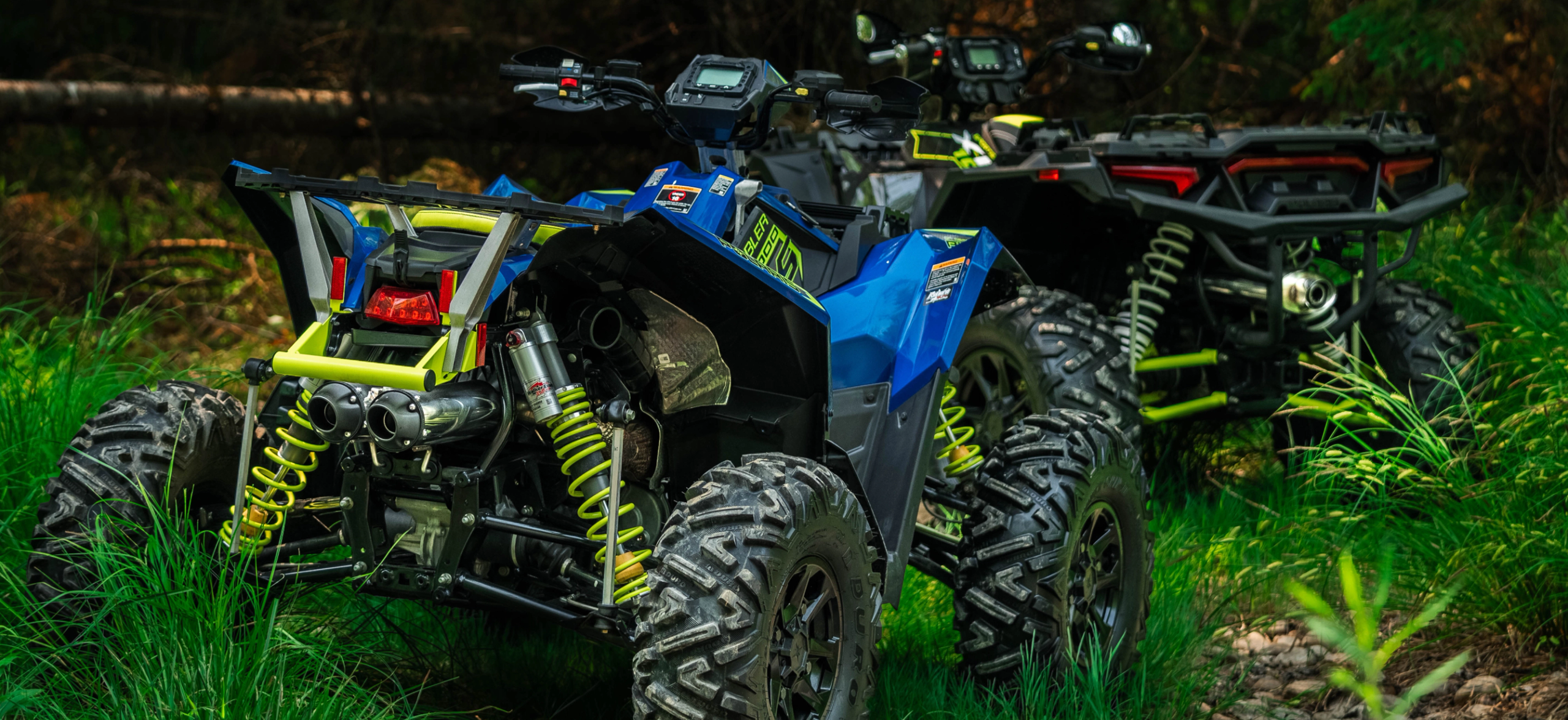 two atvs in a forest with mbrp exhaust systems installed