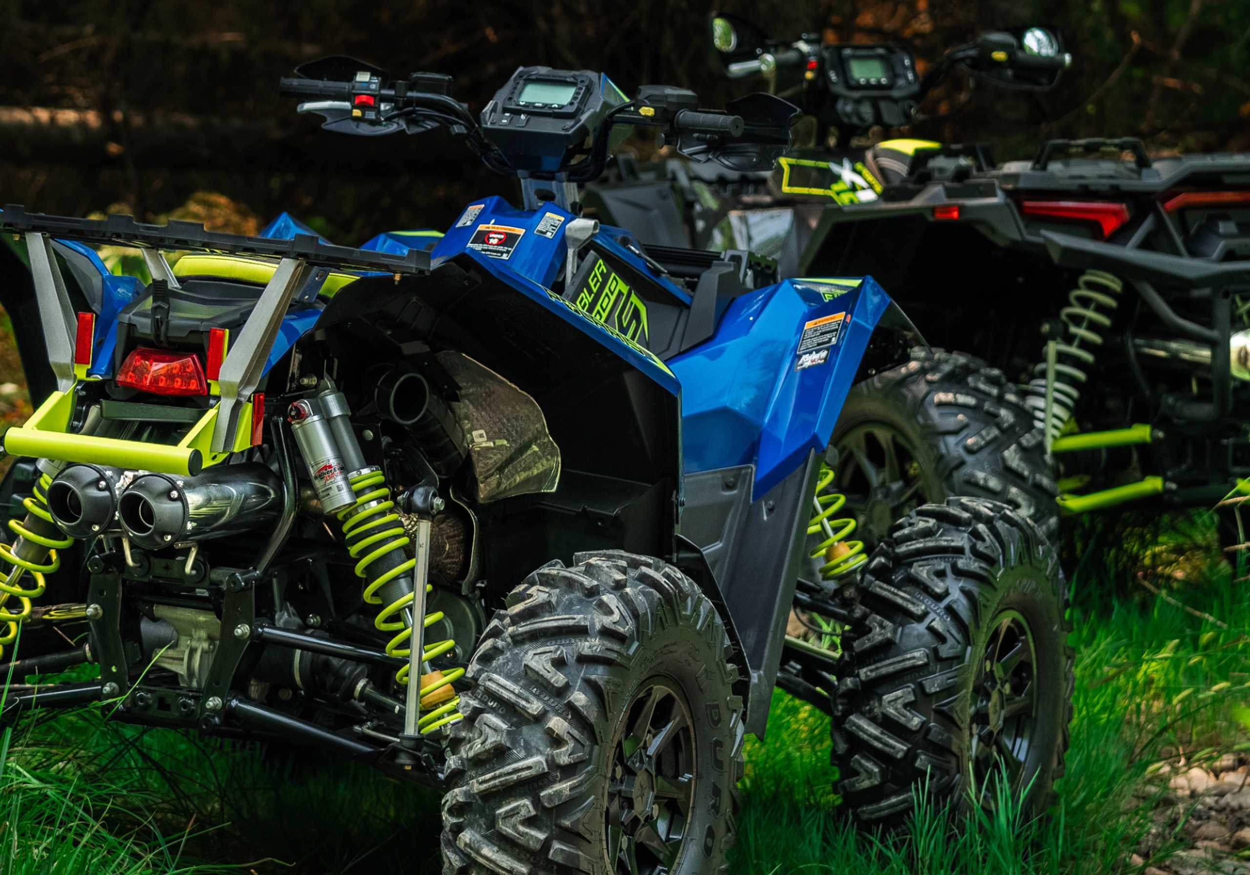 two atvs in a forest with mbrp exhaust systems installed