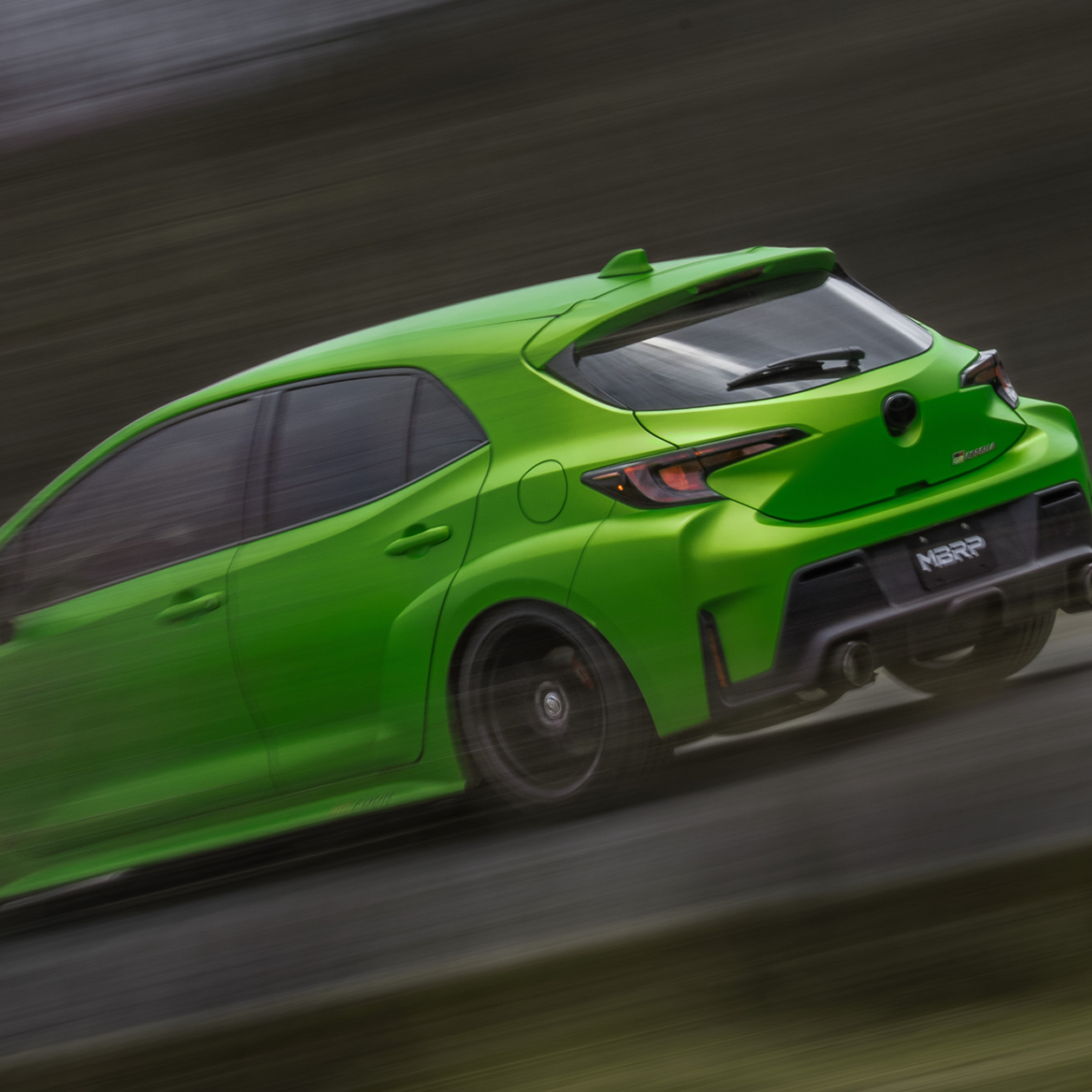 Green Toyota Corolla driving fast