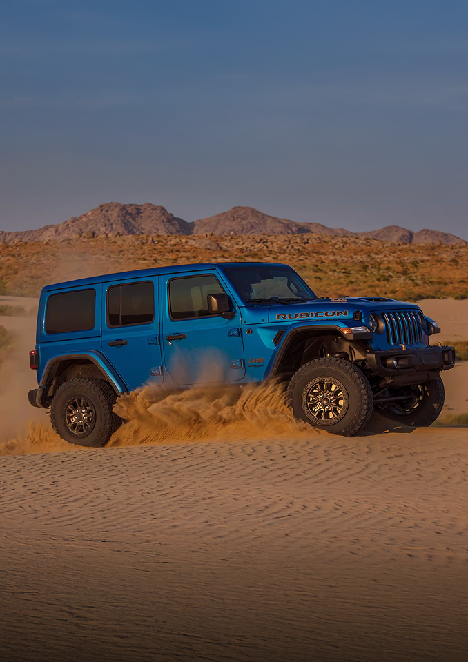 Blue Jeep Wrangler driving in the desert