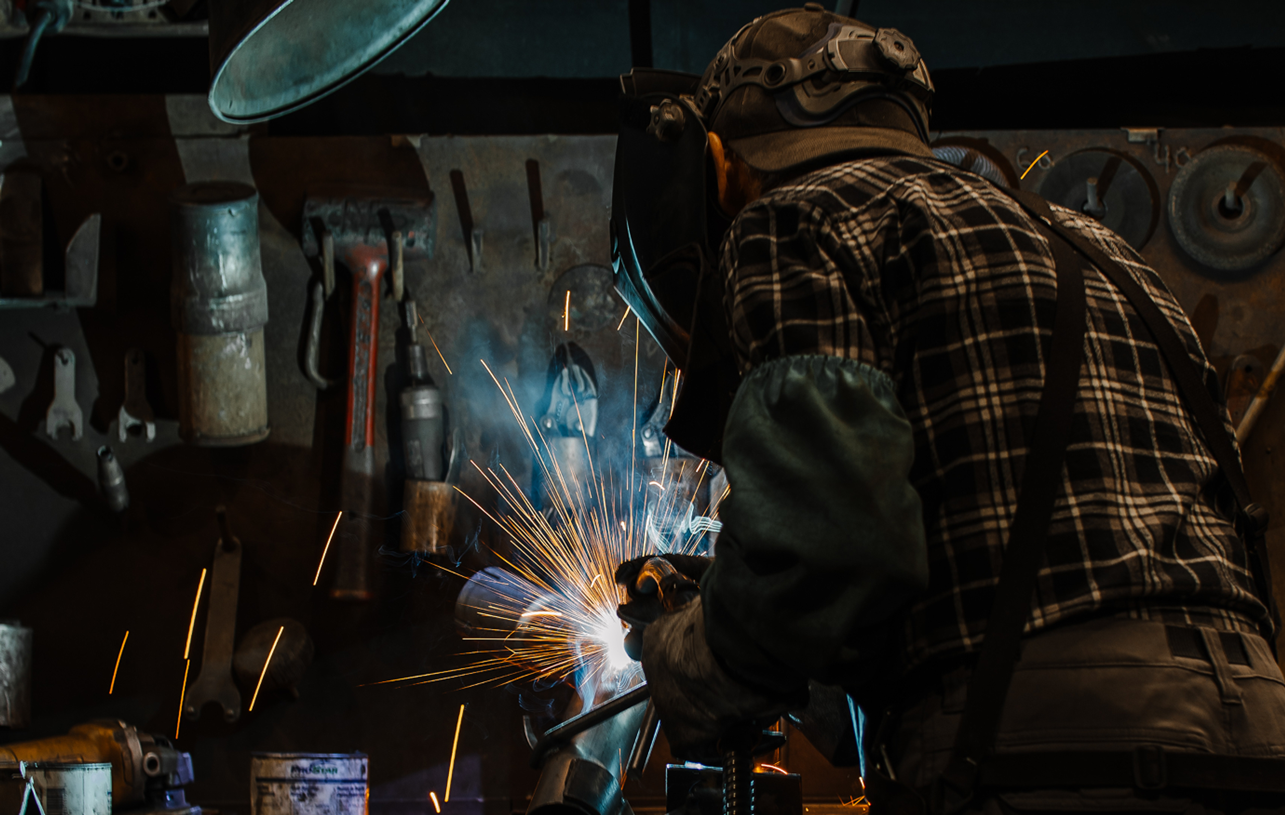 Expert welding an MBRP exhaust system in the warehouse
