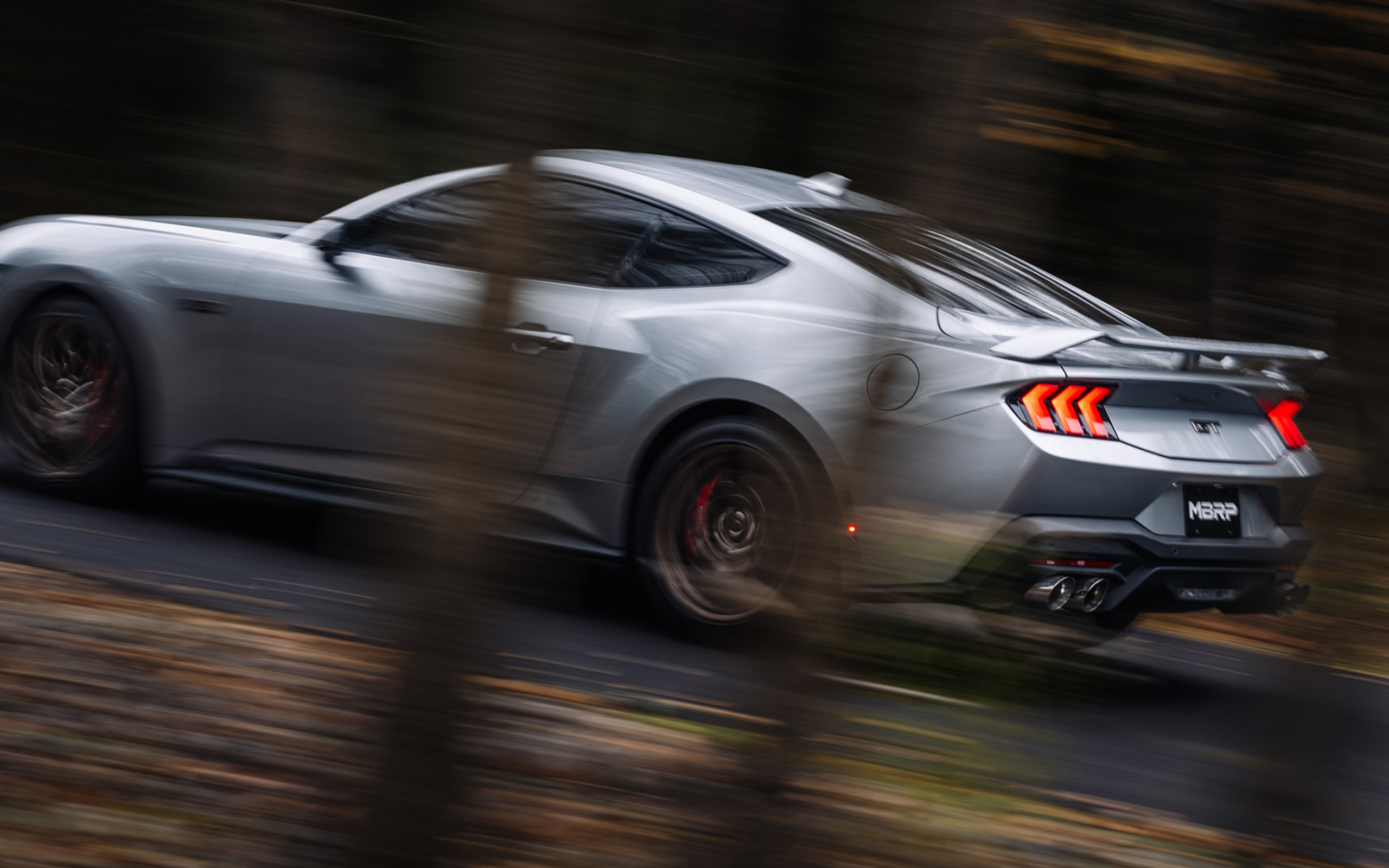 Silver GT Mustang with MBRP exhaust driving fast