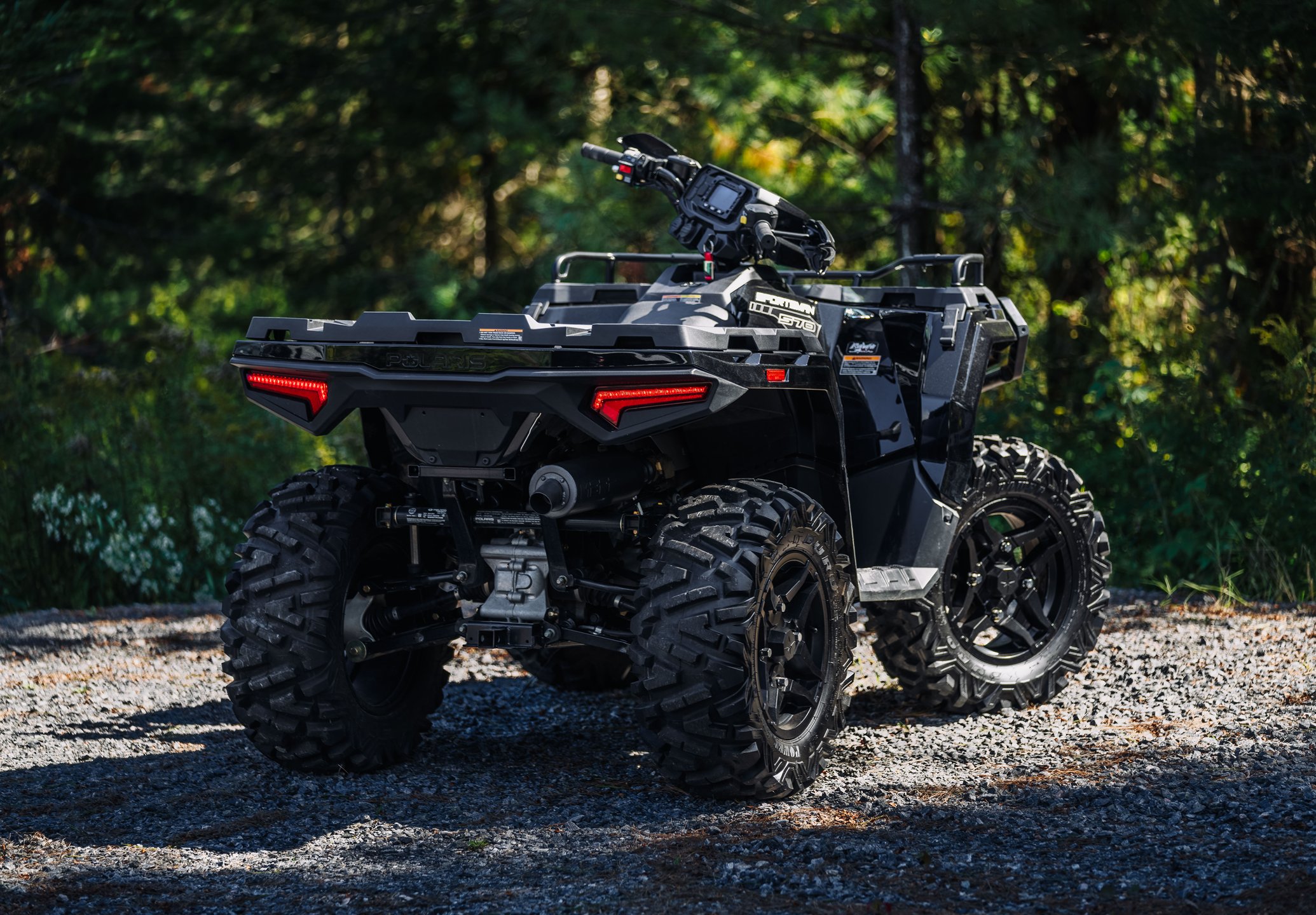 Polaris Sportsman with an mbrp exhaust installed in a forest