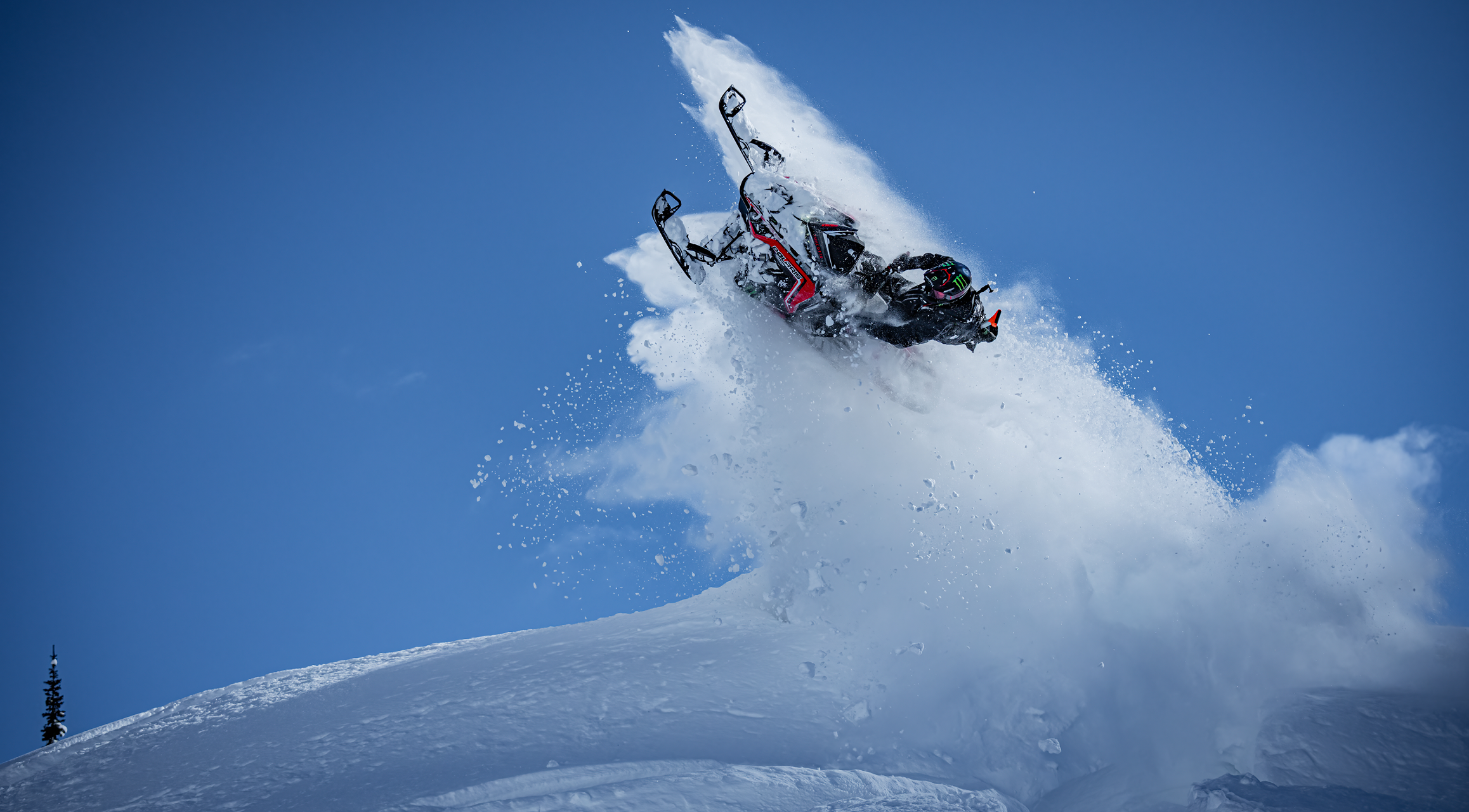 Snowmobile in the mountains doing tricks